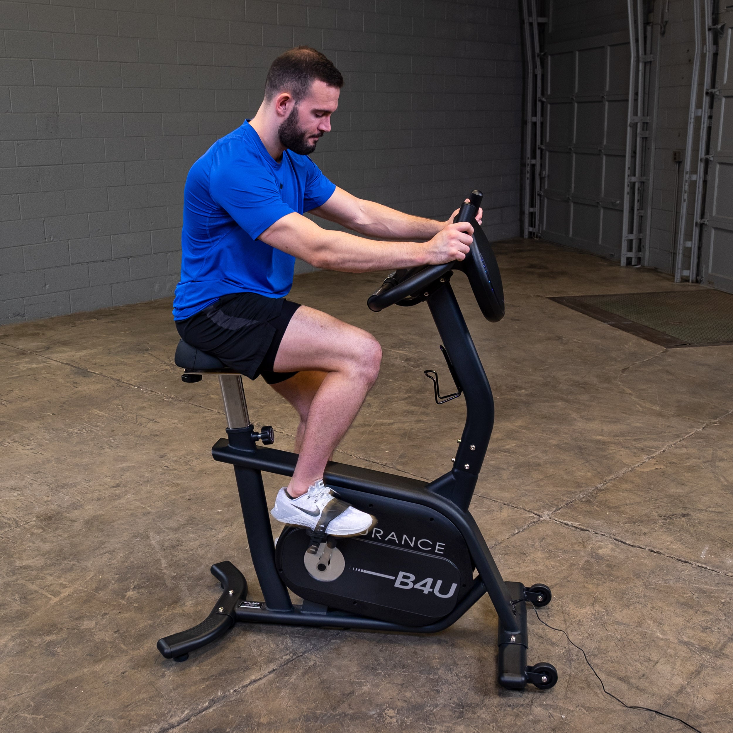 Man using Body-Solid Endurance B4UB upright exercise bike during seated cardio workout