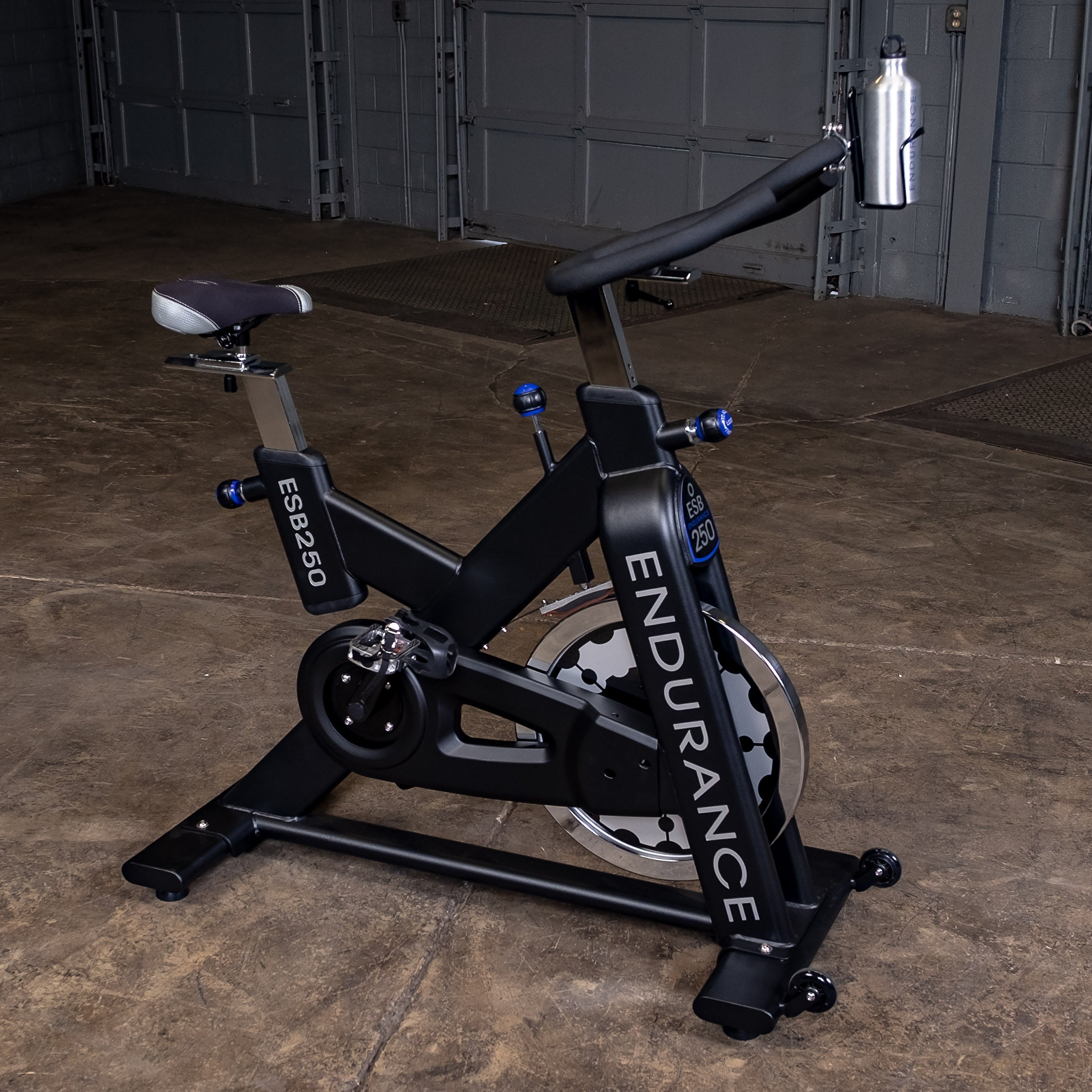 Right-side view of the Body-Solid Endurance ESB250 indoor training cycle showing the adjustable seat and handlebars, 44 lb flywheel, belt drive housing, and water bottle holder