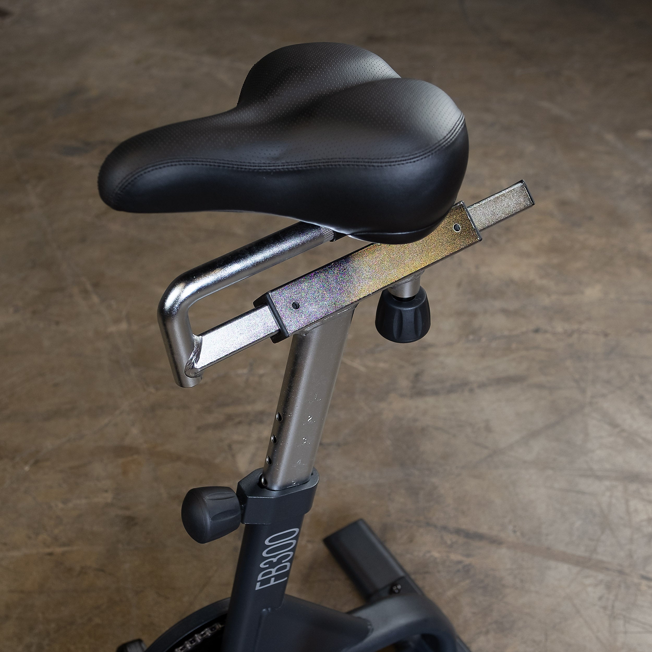 Close-up of the Body-Solid Endurance FB300B fan bike adjustable seat showing the fore and aft slider, height adjustment, and ergonomic saddle design