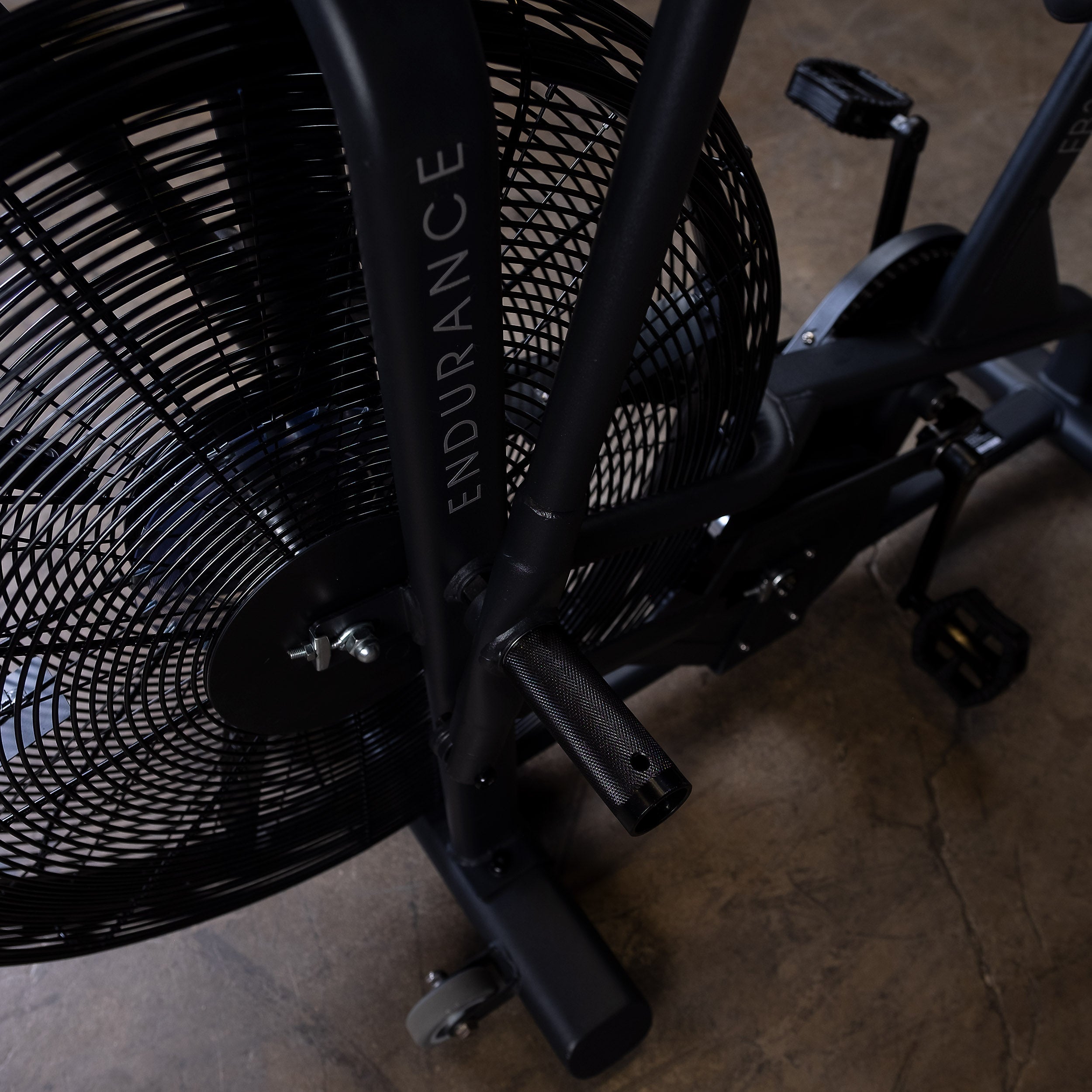 Close-up of the Body-Solid Endurance FB300B fan bike handlebars, air resistance fan, and frame highlighting the dual-action upper body handles and commercial-grade construction