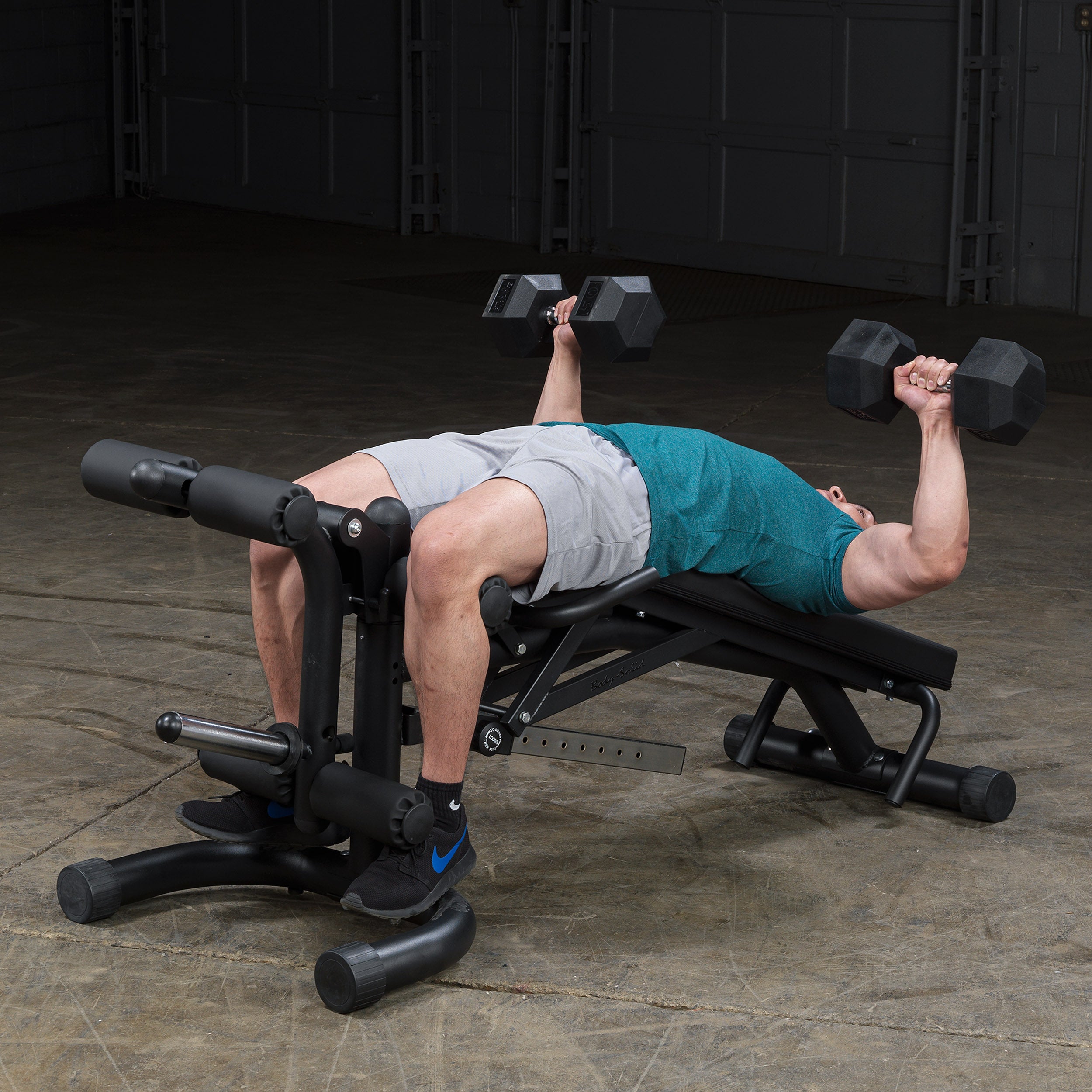 Person performing decline dumbbell bench press on the Body-Solid FID46 leverage flat incline decline bench