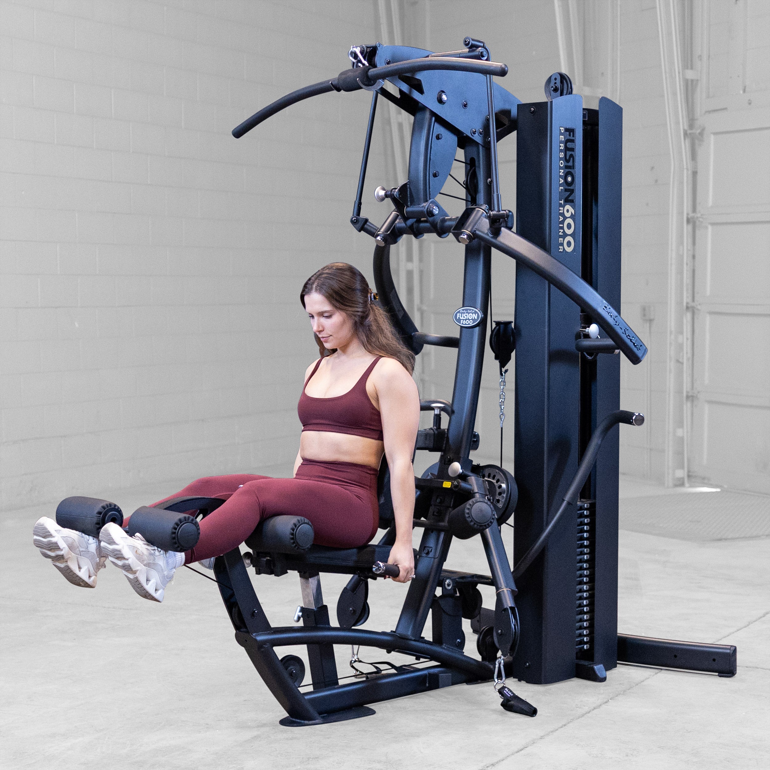 Woman performing a leg extension on the Body-Solid Fusion 600B Personal Trainer