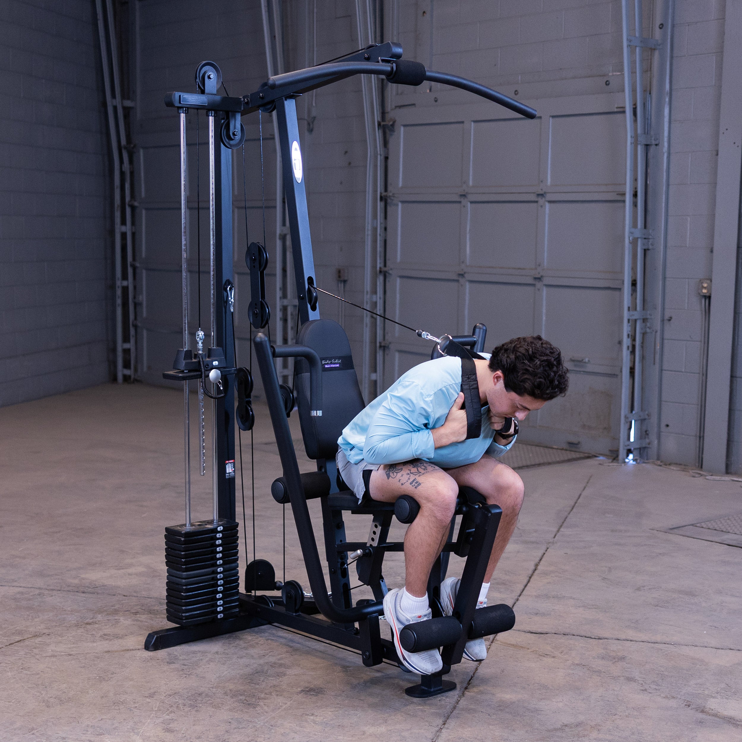 Person performing ab crunches on the Body-Solid G1B multi station home gym to strengthen the core and abdominal muscles