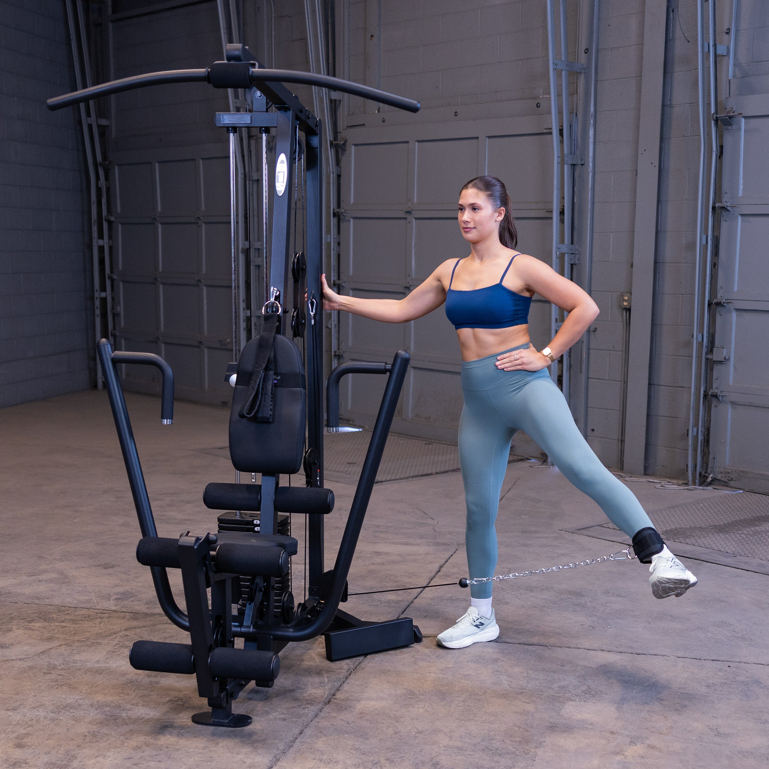 Person performing standing cable hip abductions on the Body-Solid G1B multi station home gym to strengthen the glutes and outer hips
