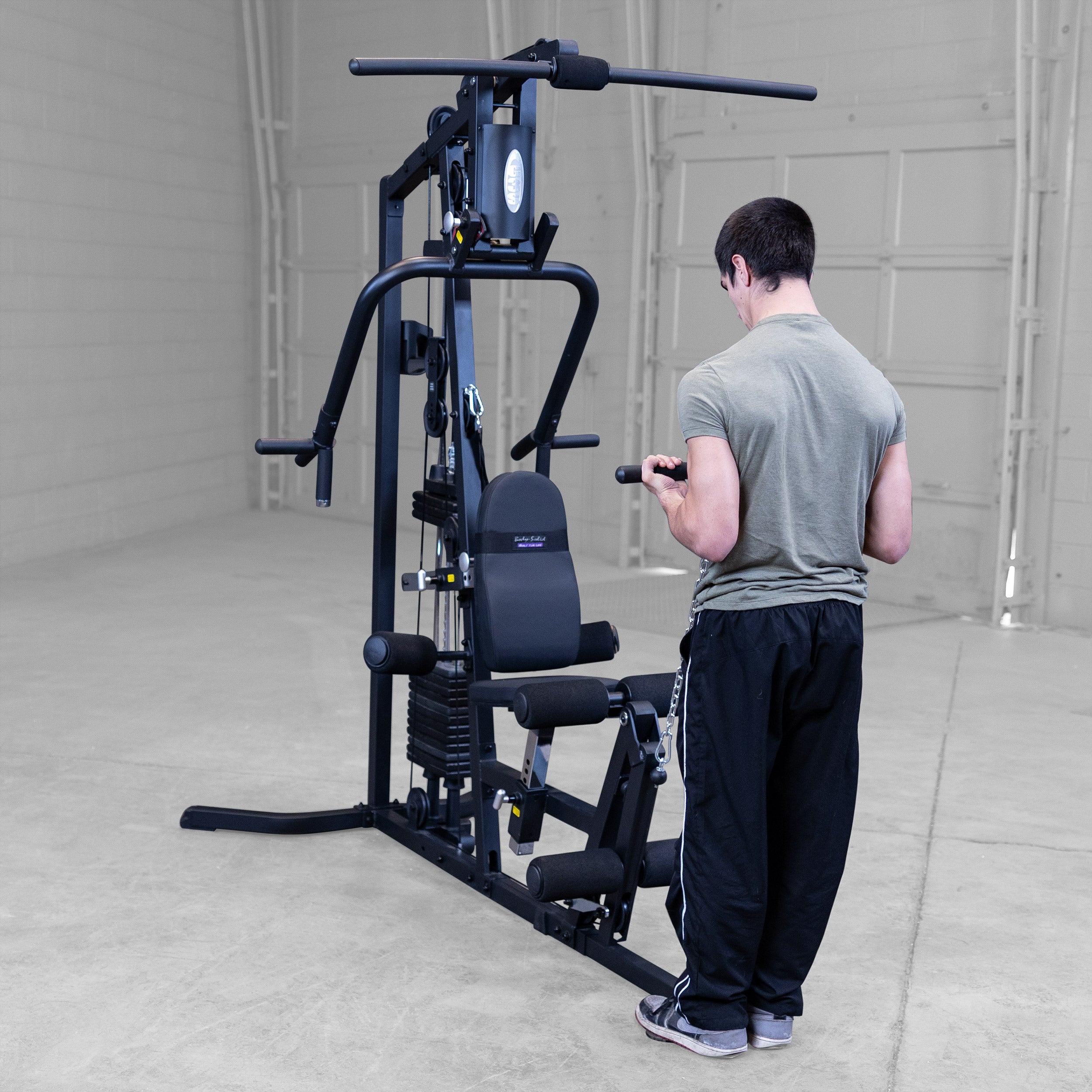 Person performing standing cable biceps curls on the Body-Solid G3B multi station home gym to strengthen the biceps