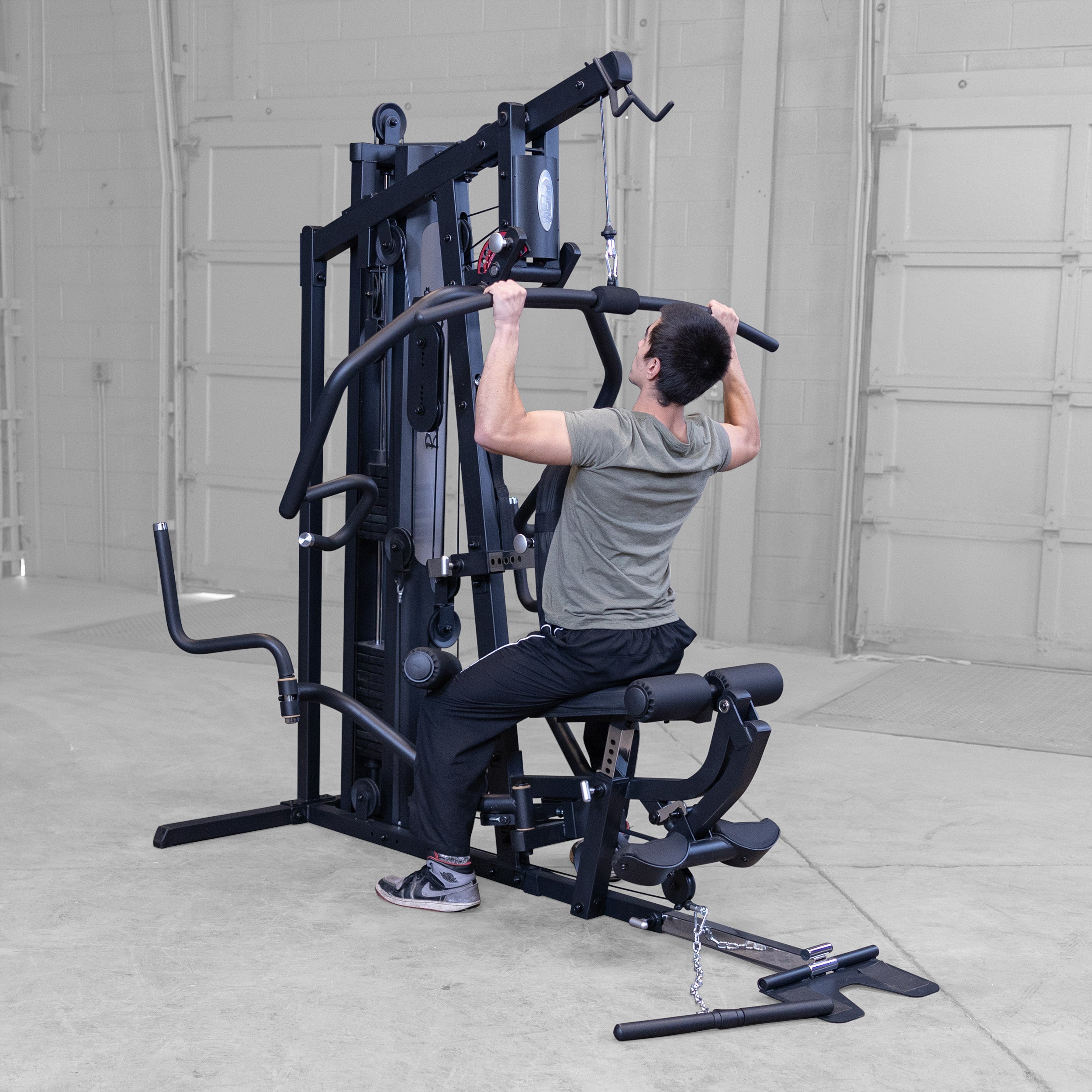Person performing lat pulldowns on the Body-Solid G5B multi station home gym to strengthen the back shoulders and biceps