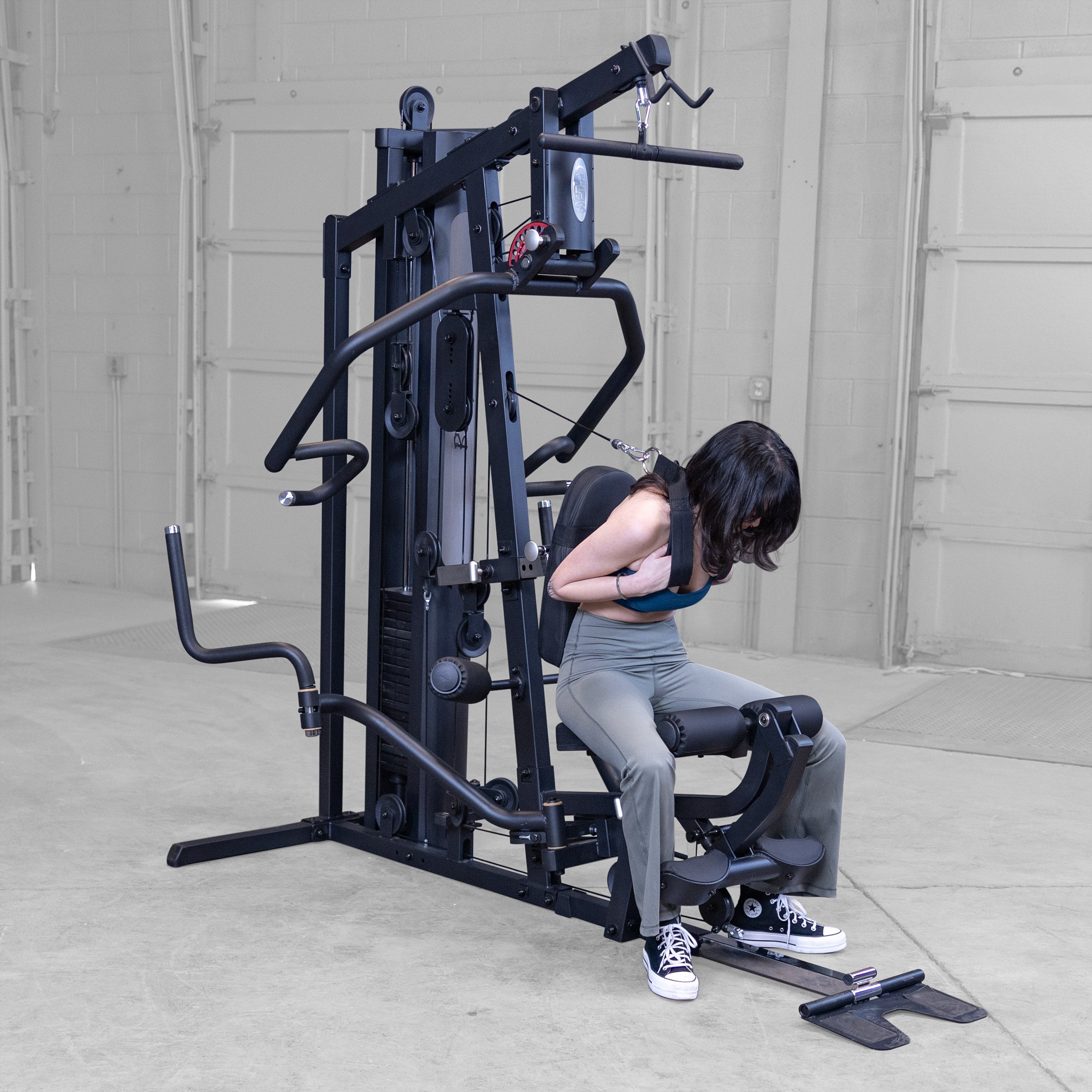 Person performing seated abdominal crunches on the Body-Solid G5B multi station home gym to strengthen the core and abdominal muscles