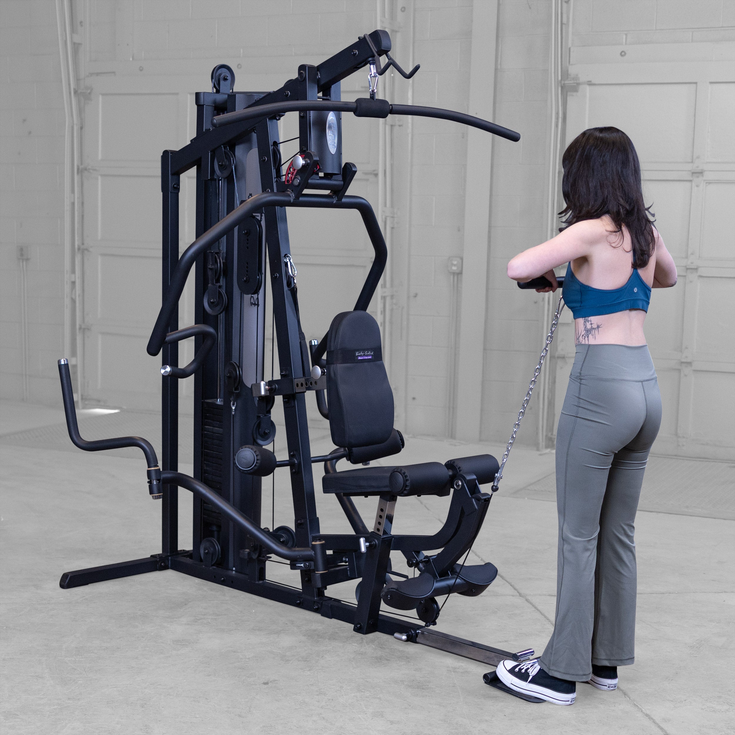 Person performing upright rows on the Body-Solid G5B multi station home gym to strengthen the shoulders and upper back