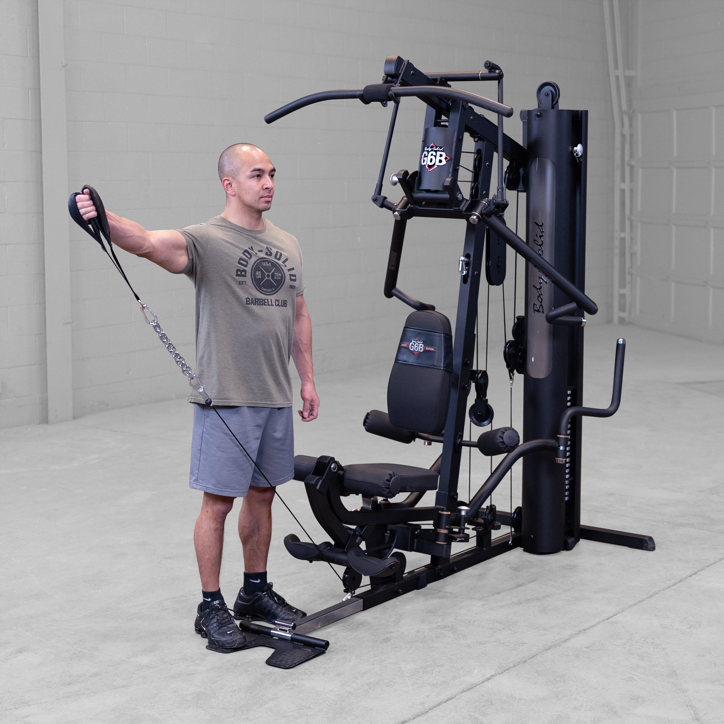 Person performing a single arm lateral raise exercise on the Body-Solid G6B Bi-Angular home gym