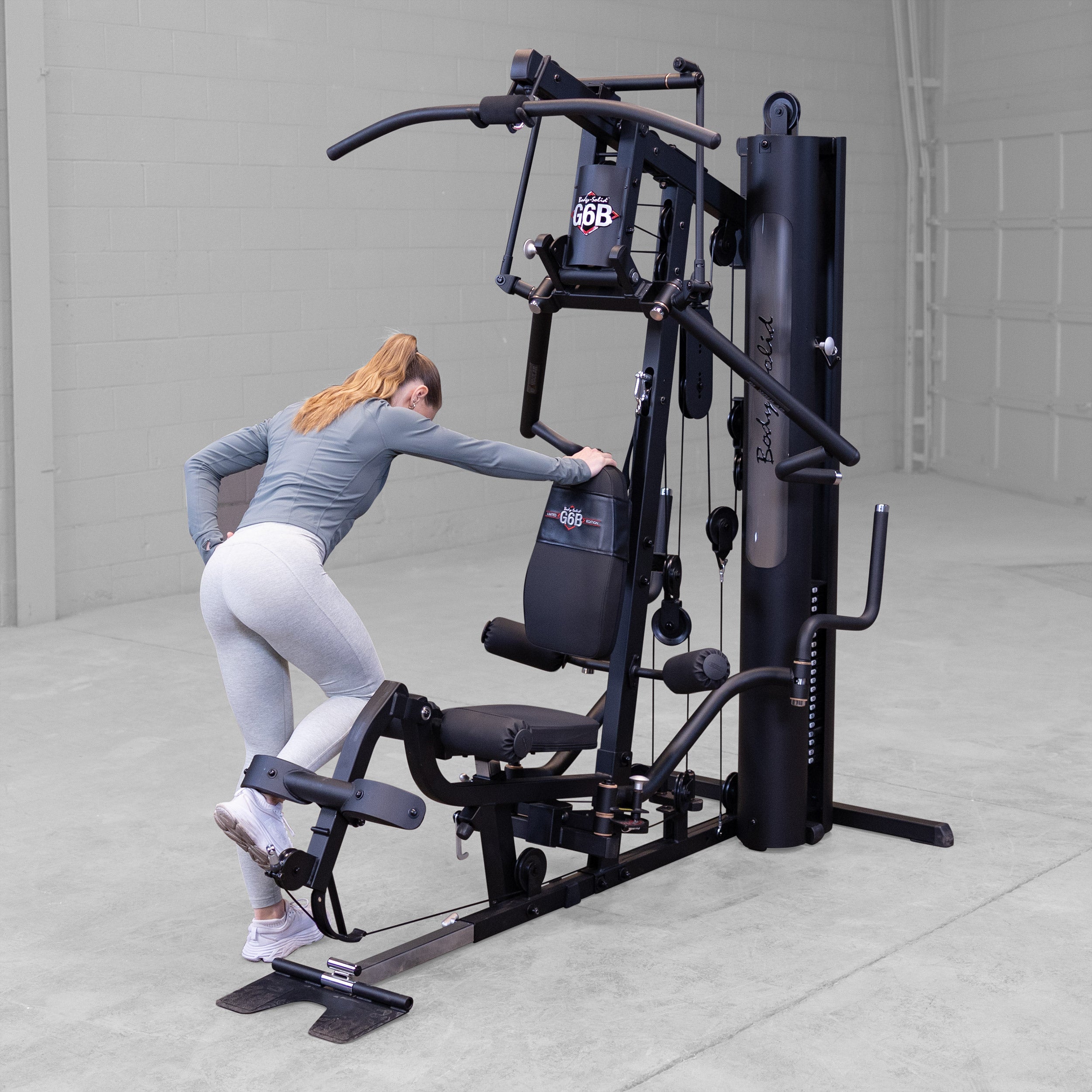 Person performing a standing leg curl exercise on the Body-Solid G6B Bi-Angular home gym