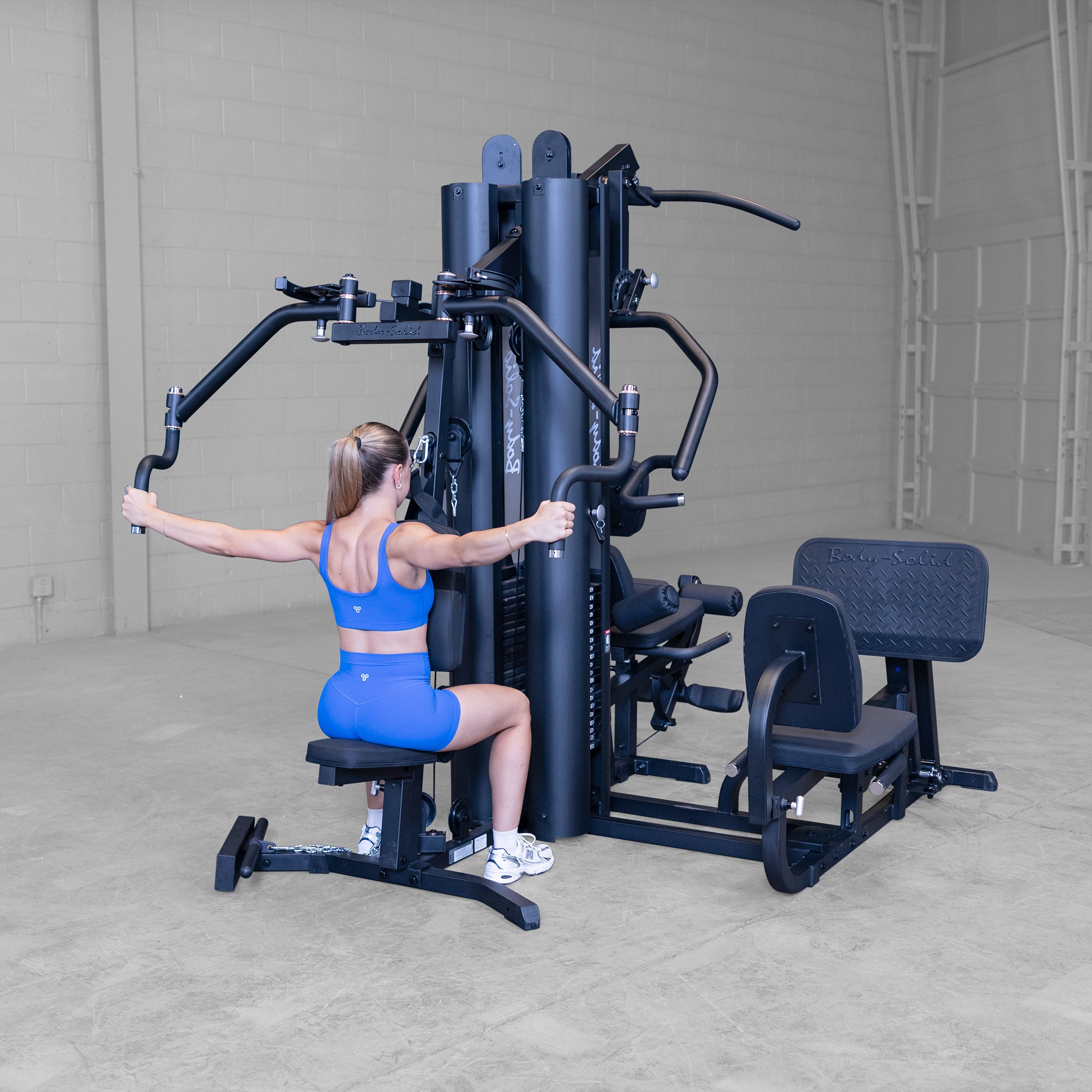 Person performing a rear deltoid fly exercise on the Body-Solid G9B dual stack multi station home gym targeting the rear shoulders and upper back