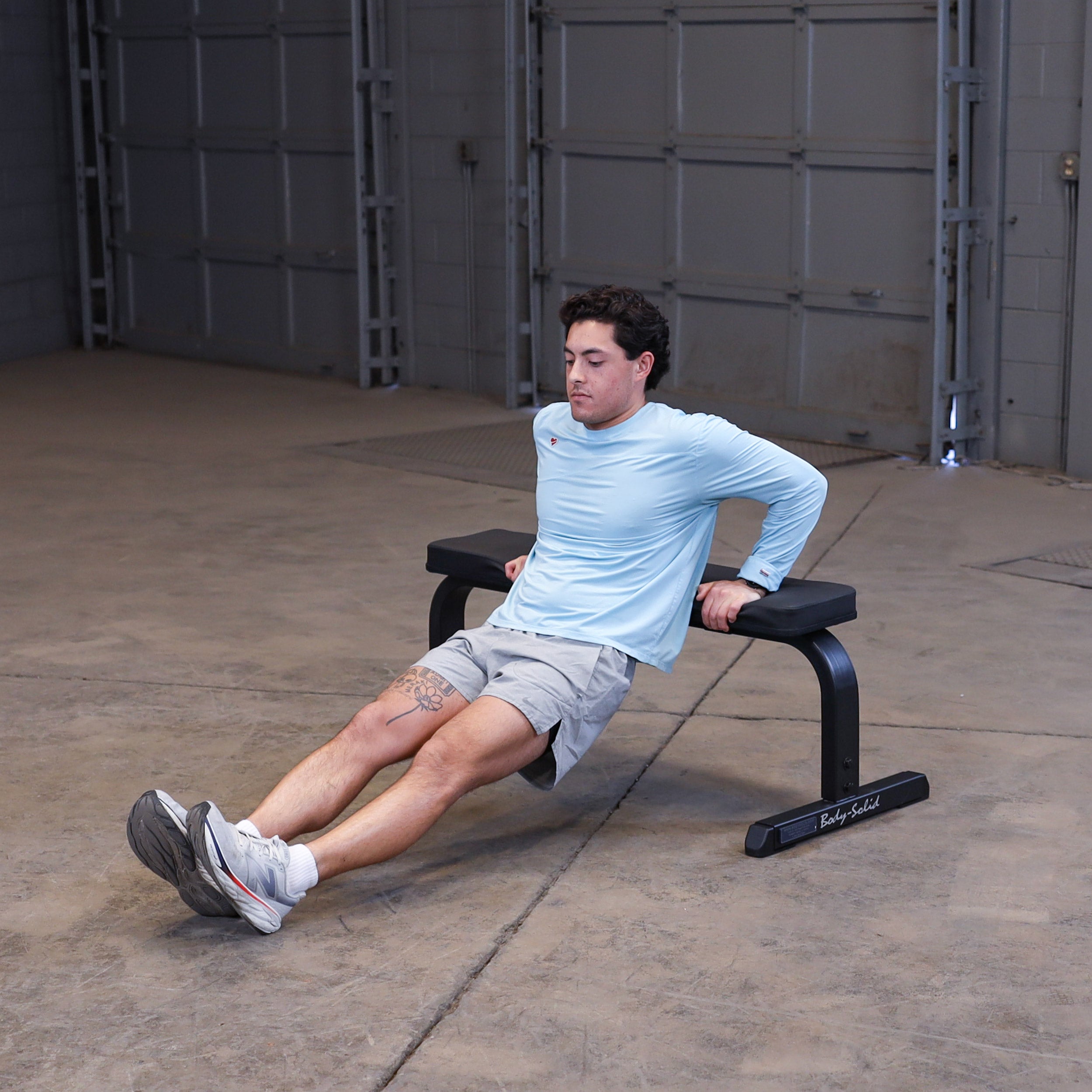 Person performing bench dips using the Body-Solid GFB350B flat bench