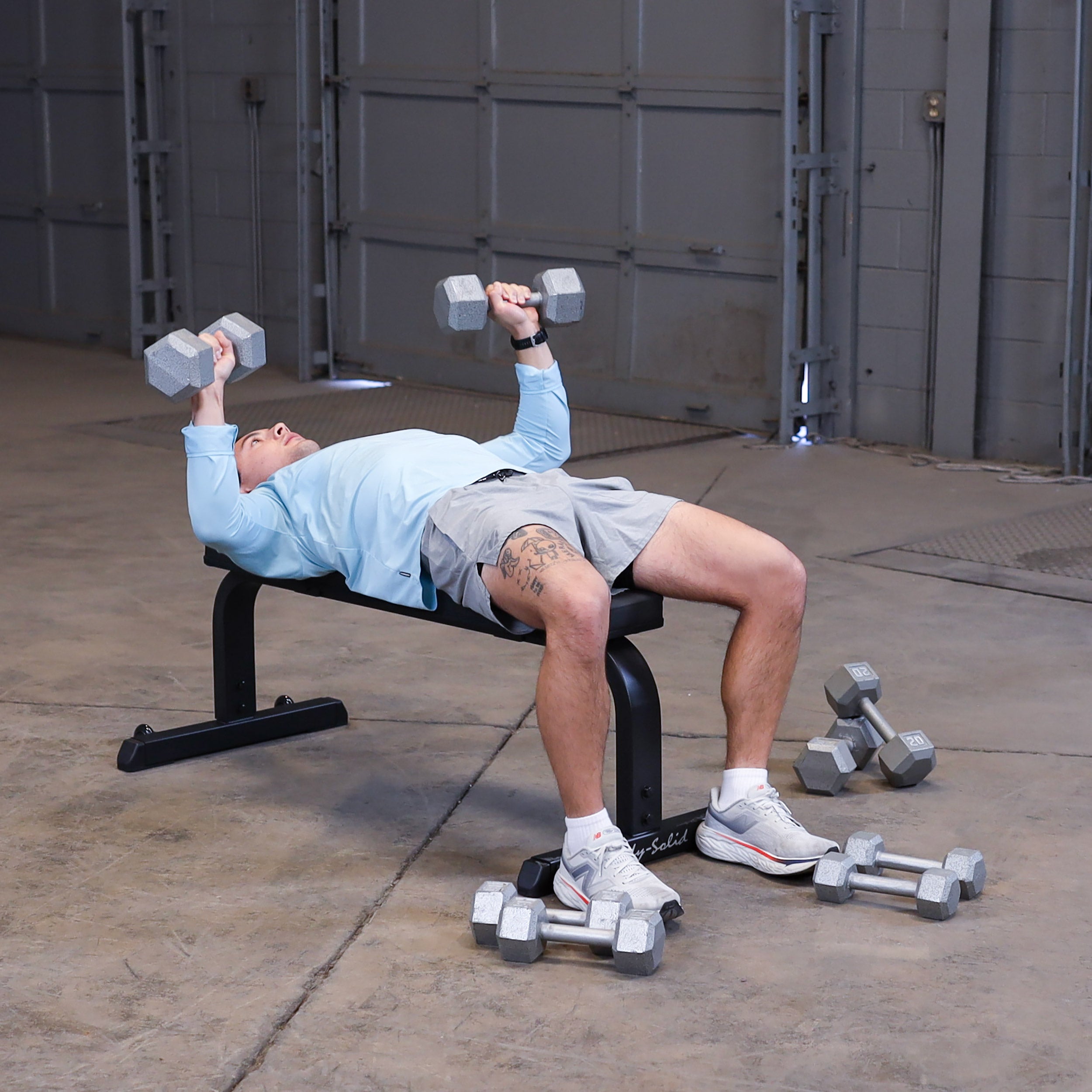 Person performing flat dumbbell bench press on the Body-Solid GFB350B flat bench
