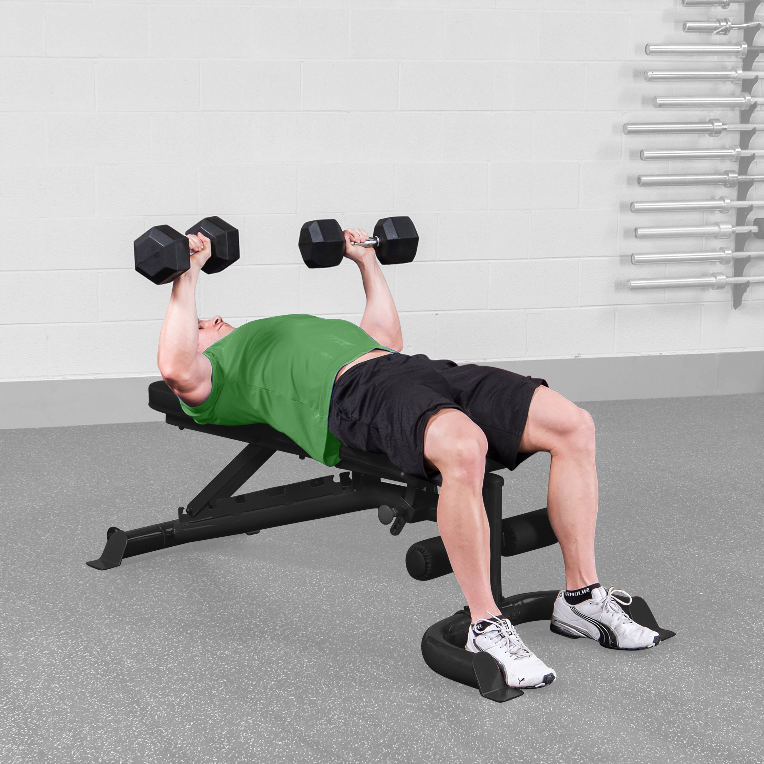 Person performing flat dumbbell bench press on Body Solid GFID100B adjustable weight bench in a home gym