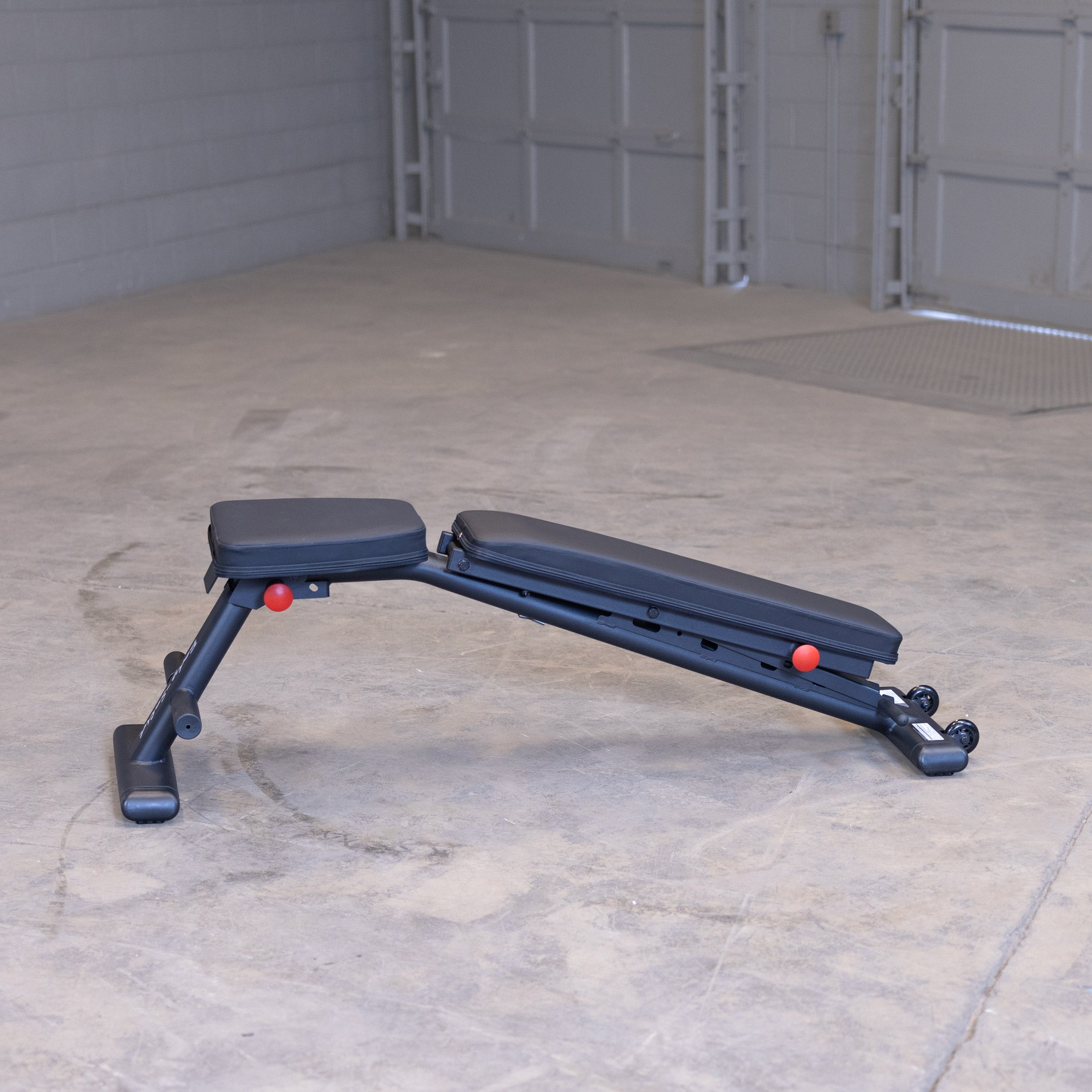 Body Solid GFID225B folding adjustable weight bench shown in decline position for home gym strength training