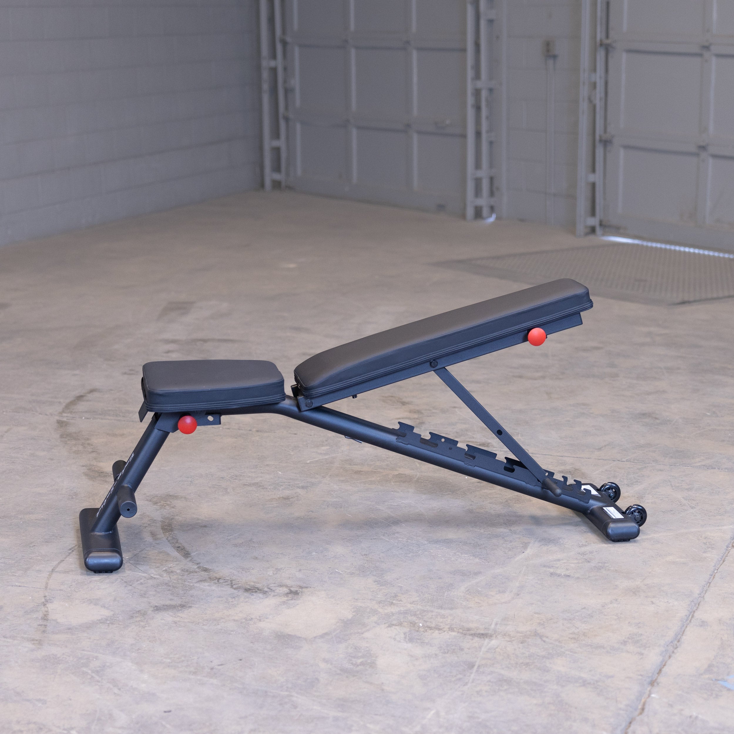Body Solid GFID225B folding adjustable weight bench shown in low incline position for home gym strength training