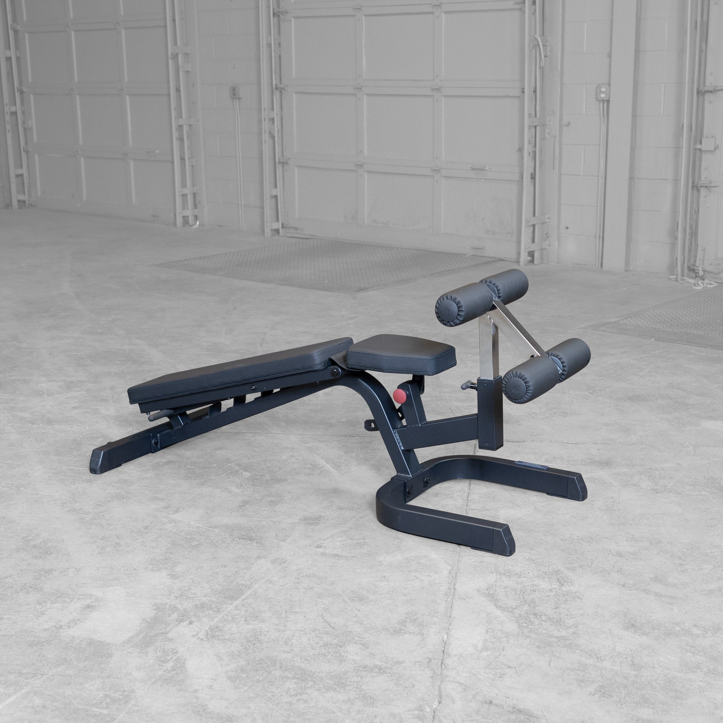 Body-Solid GFID71B Heavy Duty Flat Incline Decline Bench shown in the full decline position with integrated leg hold-down attachment and commercial-grade steel frame