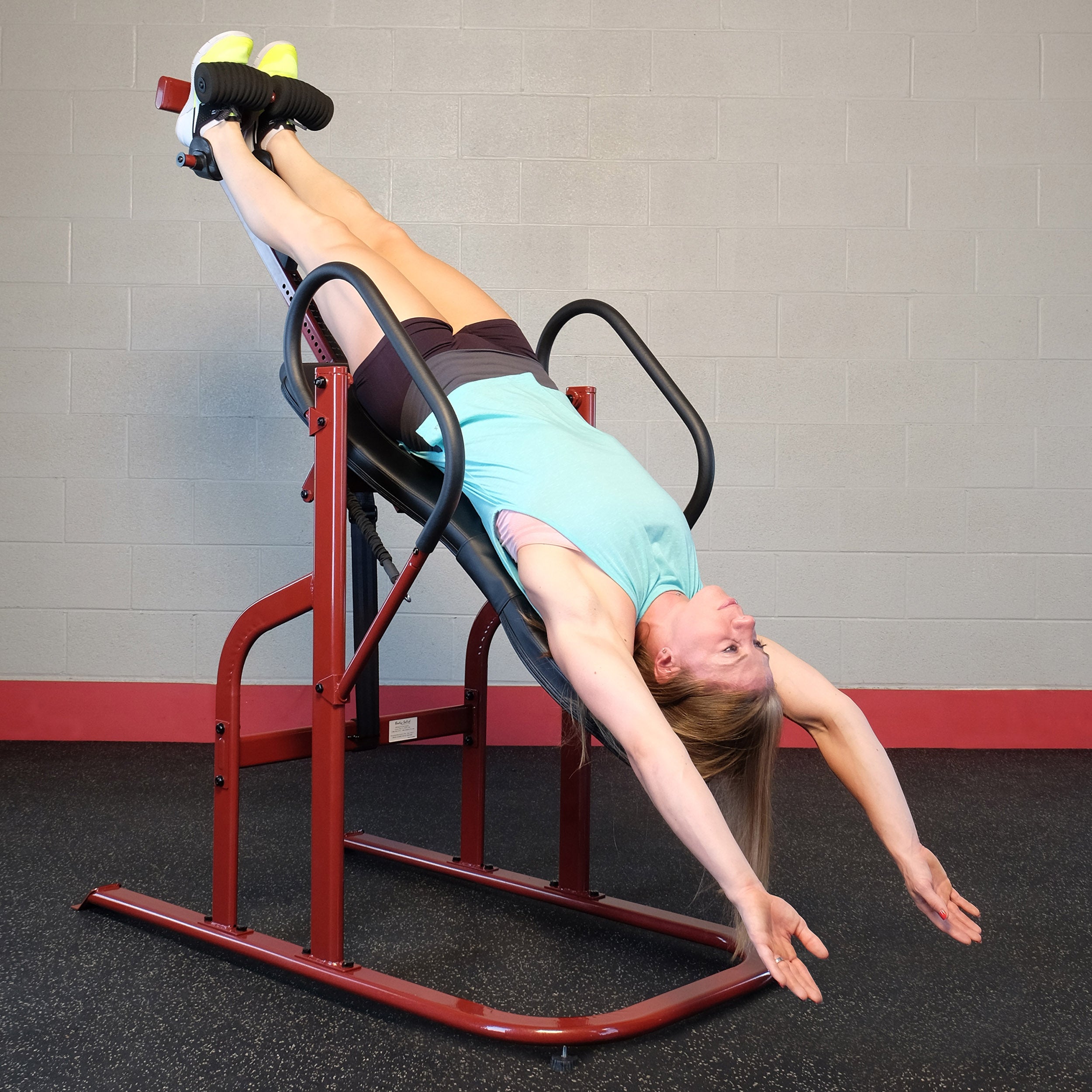 Woman using the Body-Solid GINV50 Inversion Table in a full inversion position