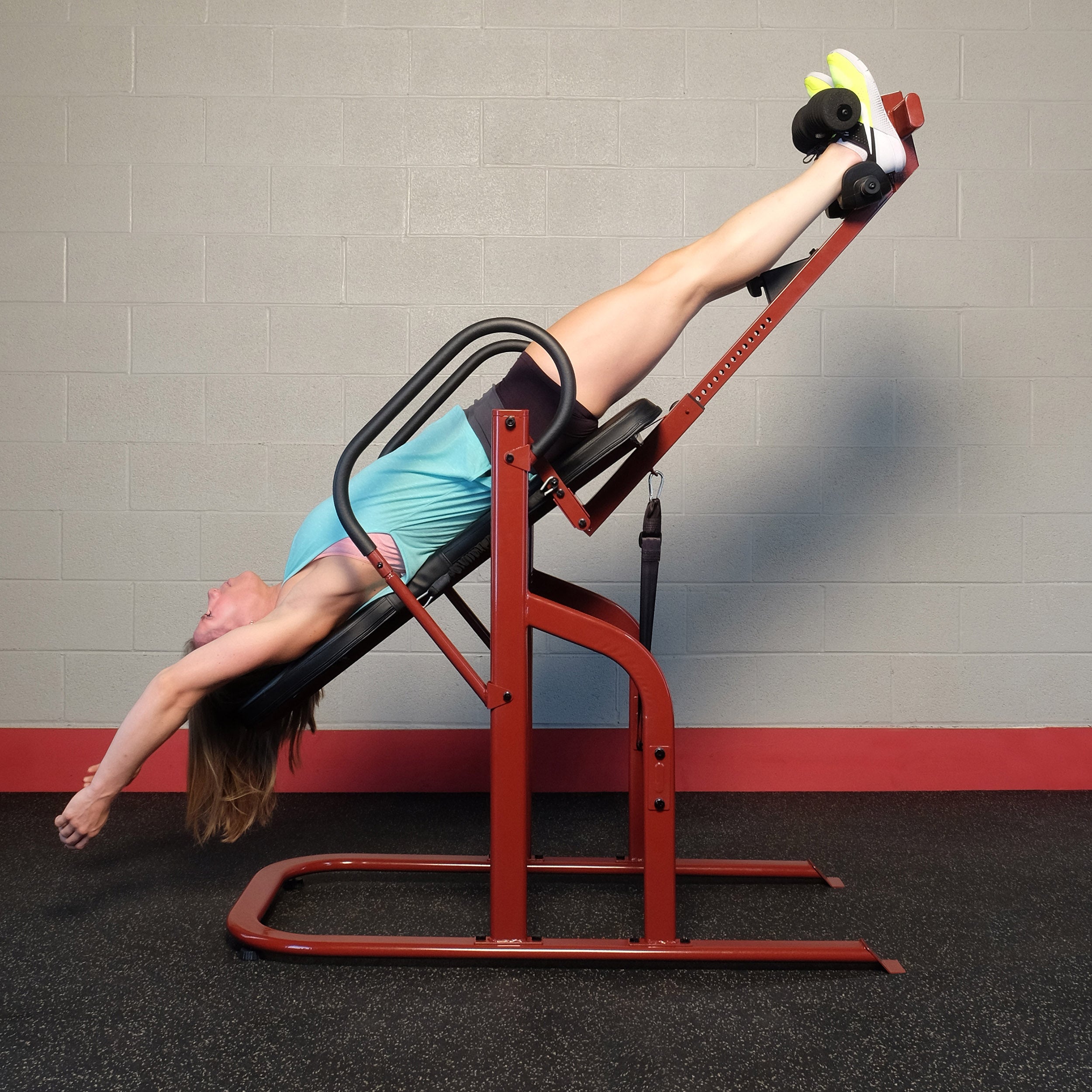 Woman using the Body-Solid GINV50 Inversion Table in an inverted stretching position from the side