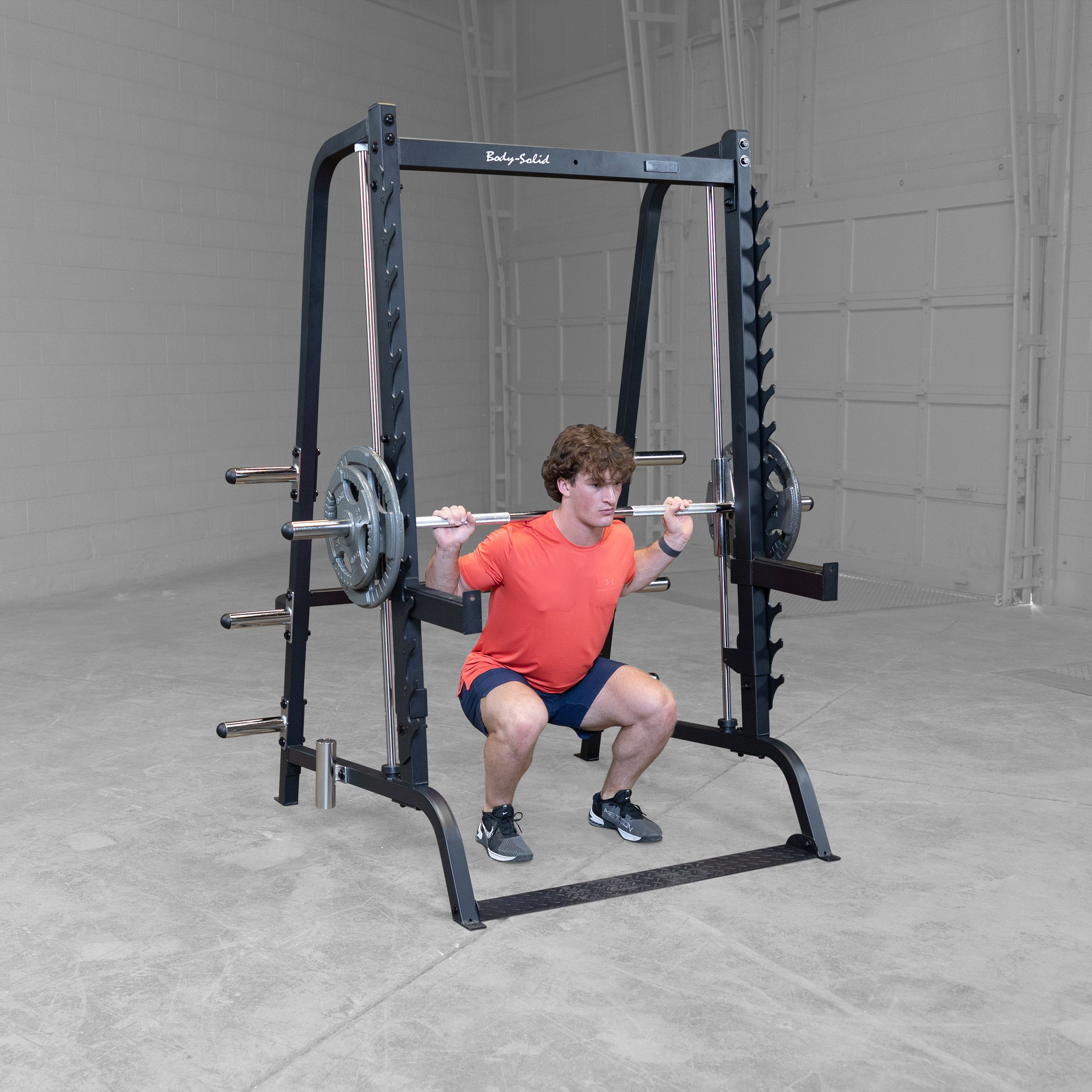 Athlete performing Smith machine squats on the Body-Solid GS348B Series 7 Smith Machine using the 7° angled guided bar with Olympic weight plates