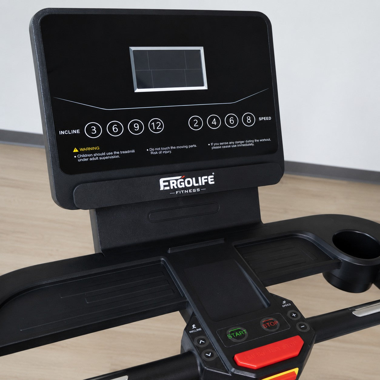 Close-up of the ERGOLIFE 102 treadmill console with built-in display, speed and incline controls, tablet holder, and emergency stop button