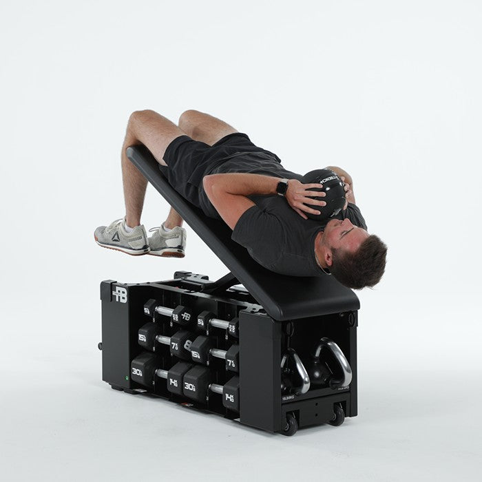 Man performing slam ball decline sit-up on FITBENCH One NXT Gen workout bench