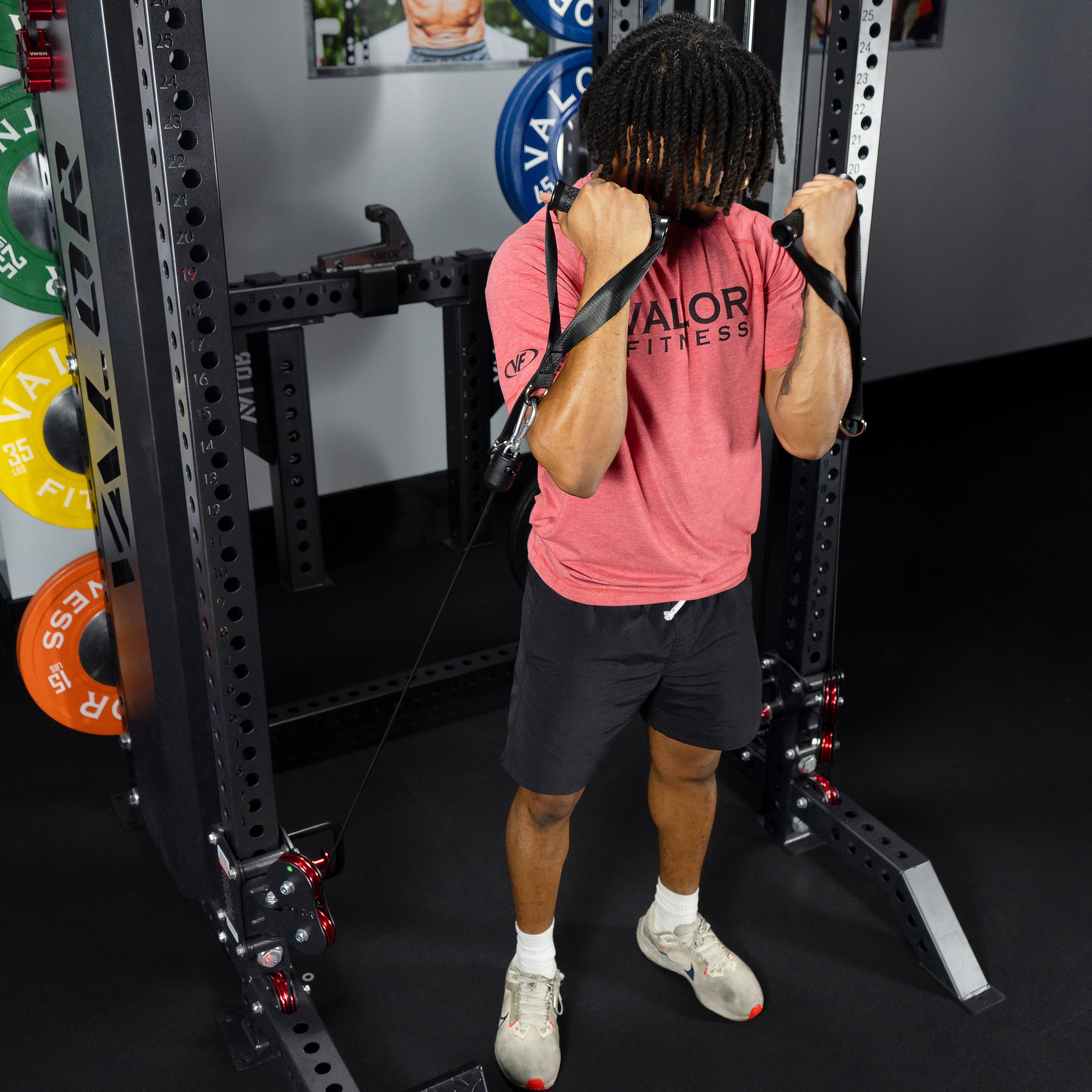 Athlete performing standing cable bicep curls on the Valor Fitness BD-83 functional trainer power rack using dual cable handles