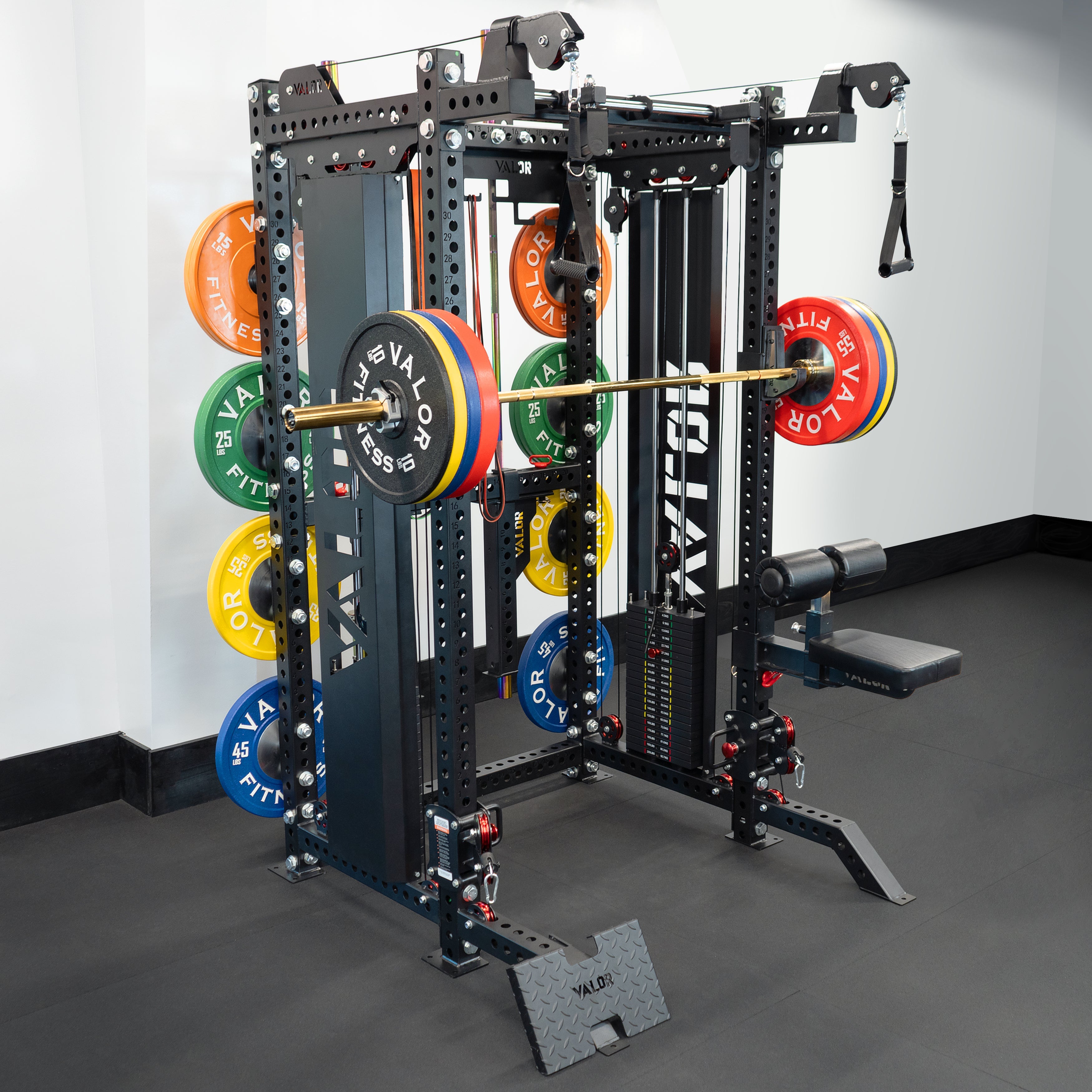 Valor Fitness BD-83 functional trainer power rack with loaded Olympic barbell, dual weight stacks, plate storage pegs, and cable pulley system in gym setting