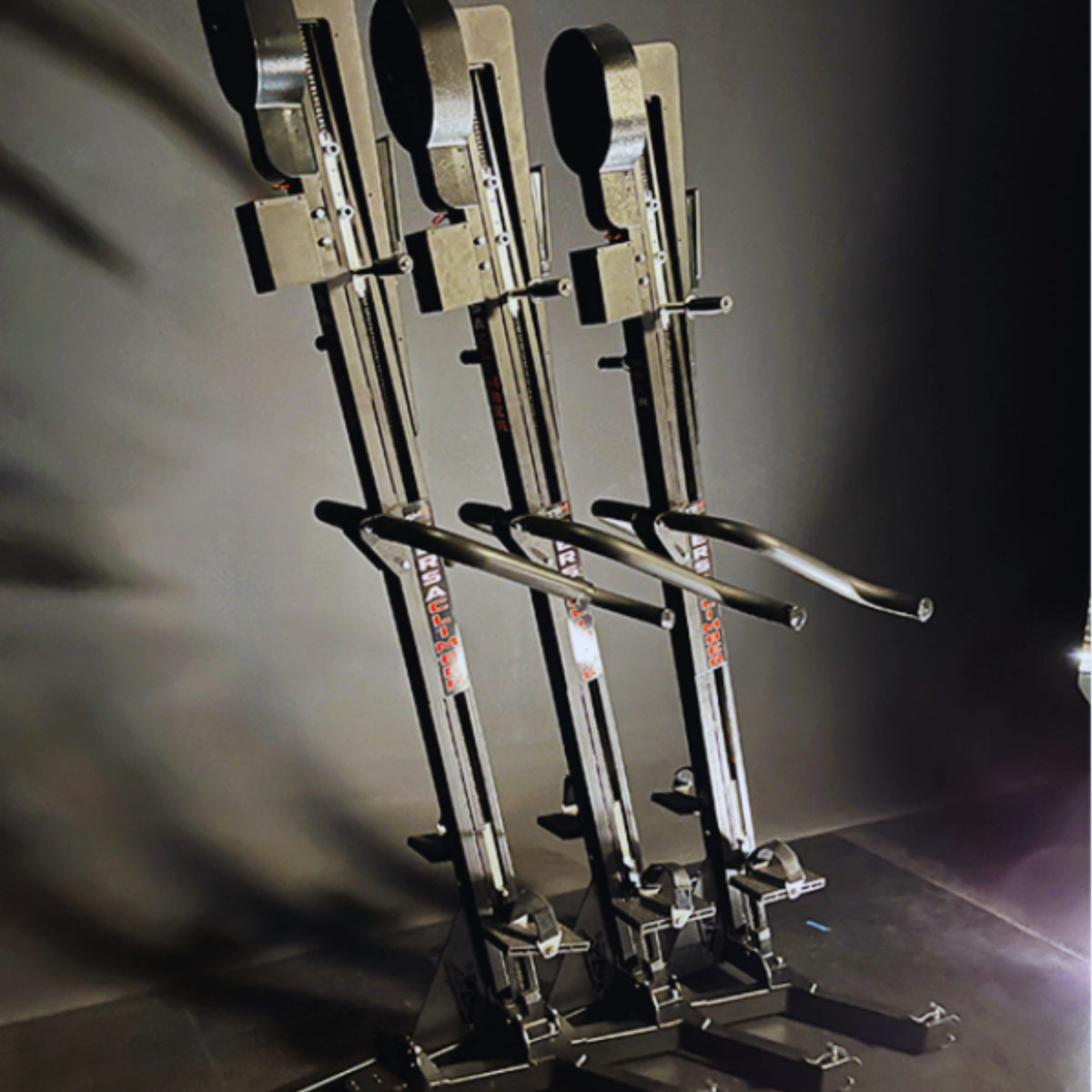 Three VersaClimber vertical climbing machines arranged side by side with stackable bases for compact gym storage