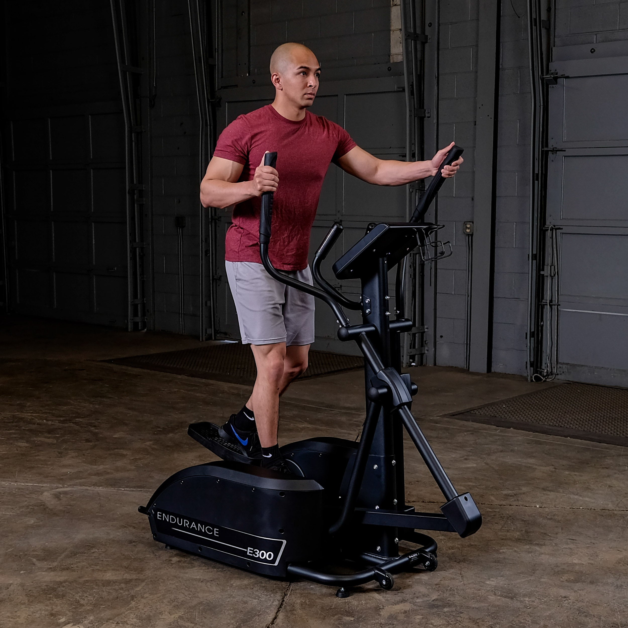 Man using Body-Solid Endurance E300 elliptical trainer for low-impact full-body cardio workout