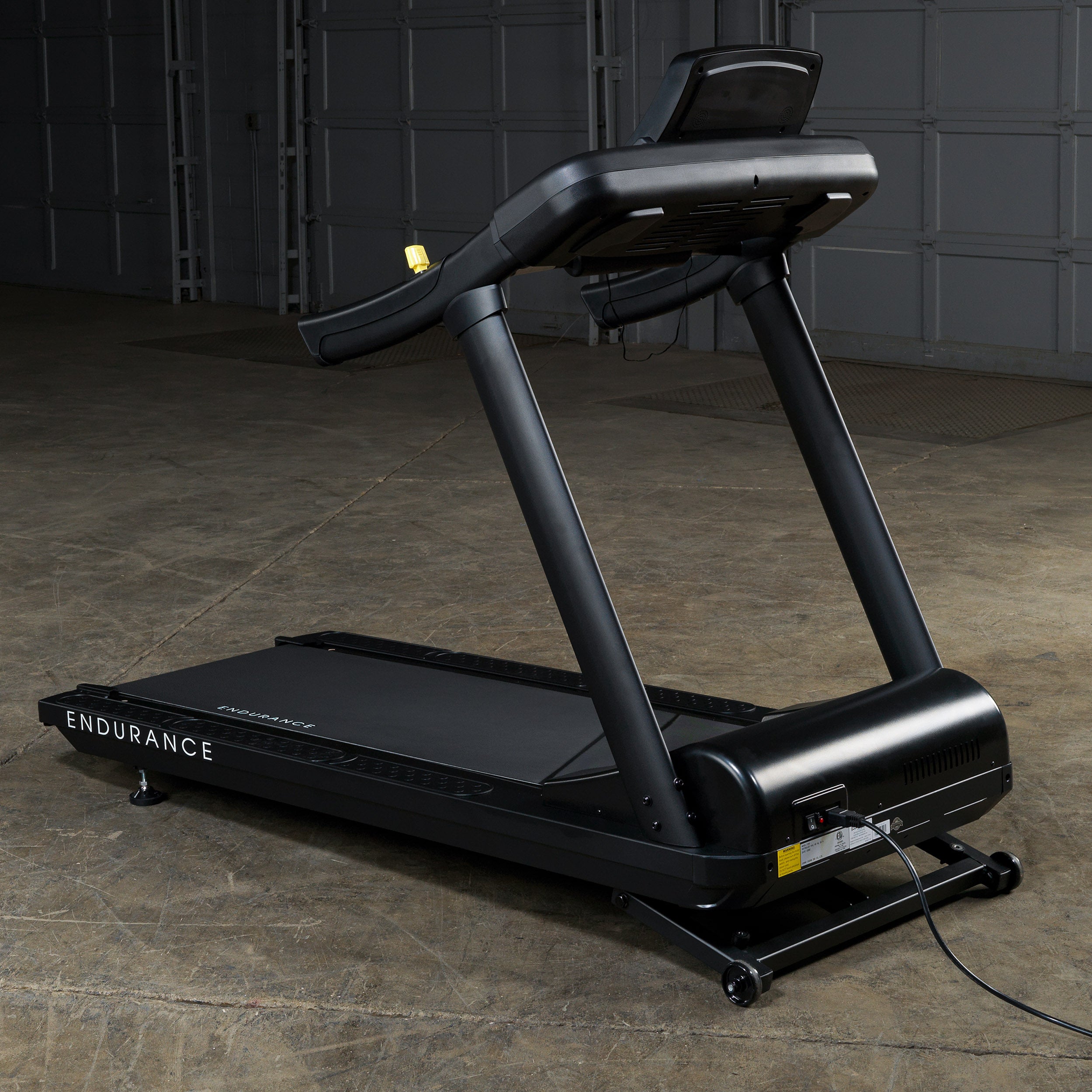 Rear view of Body-Solid Endurance T150 commercial treadmill showing frame and motor housing in gym setting