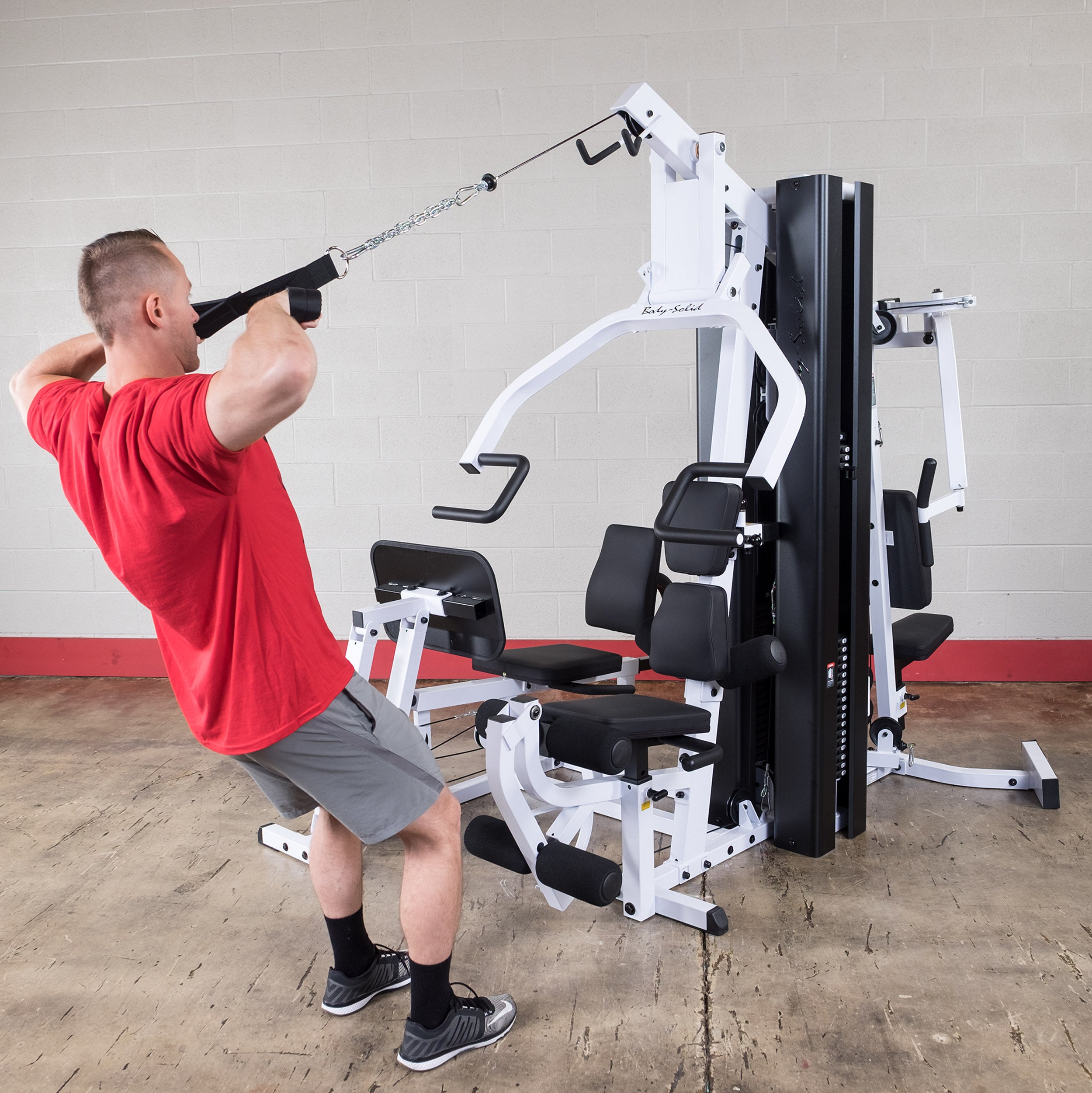 Person performing high row exercises on the Body-Solid EXM3000LPS dual stack multi-station gym