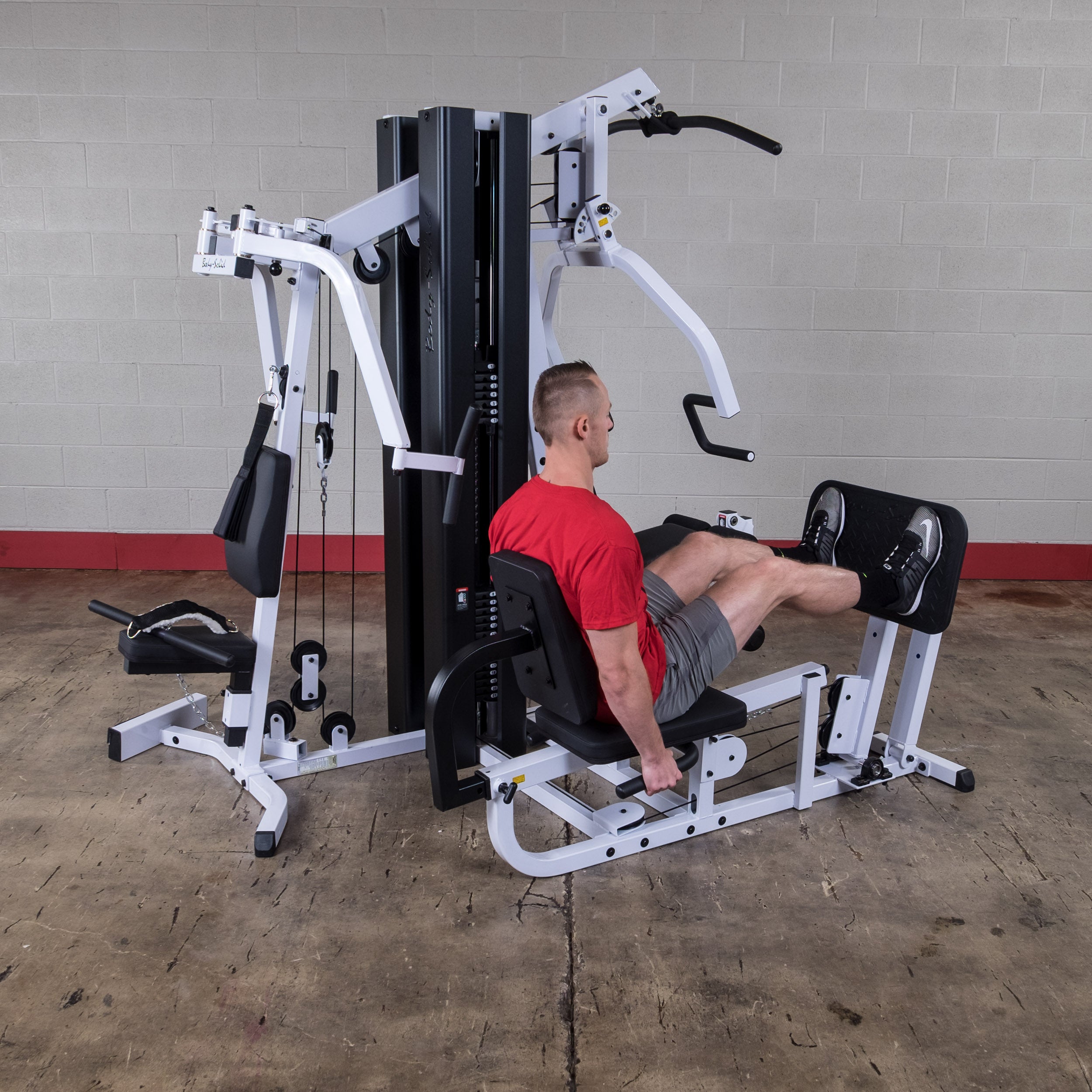 Person performing leg press exercises on the Body-Solid EXM3000LPS dual stack multi-station gym