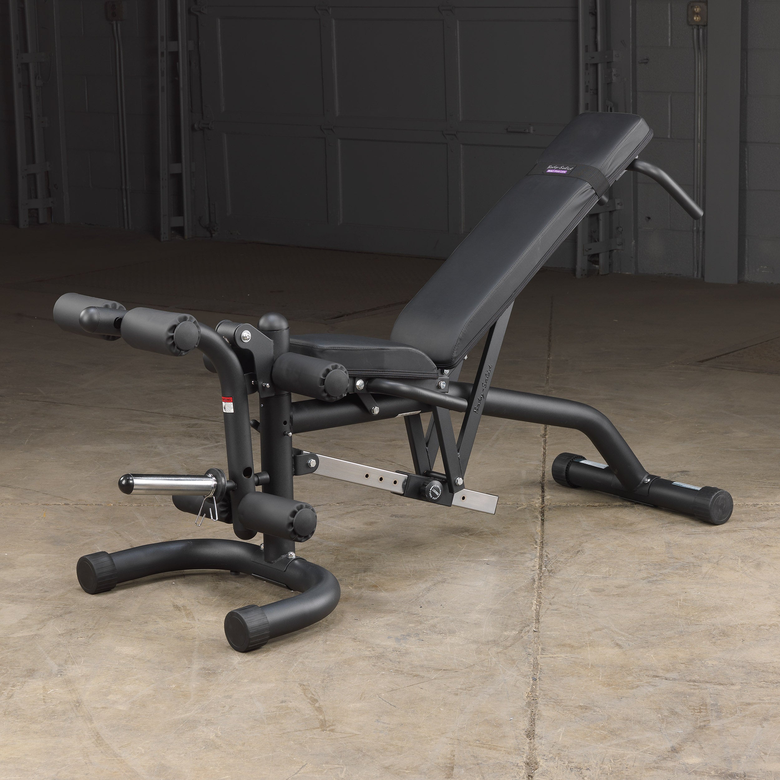 Body-Solid FID46 leverage flat incline decline bench with integrated leg developer shown in a home gym setting in the incline position