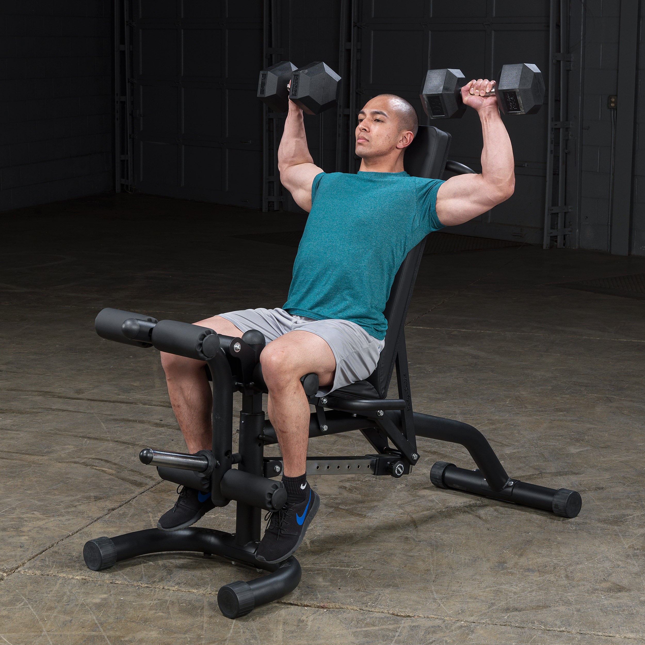 Person performing seated dumbbell shoulder press on the Body-Solid FID46 leverage flat incline decline bench in the incline position