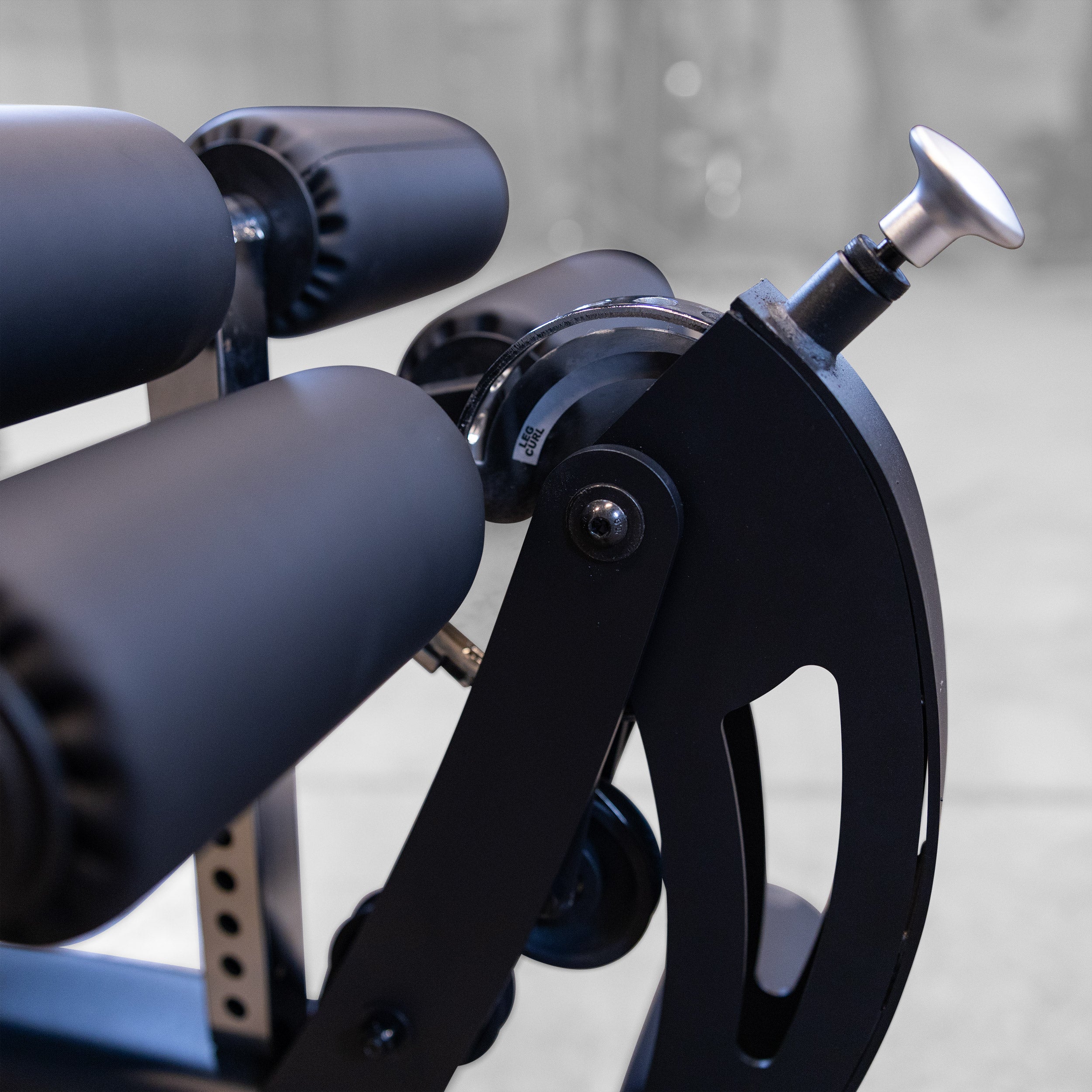 Close-up of the Body-Solid Fusion 600B leg developer adjustment mechanism for leg extension and seated leg curl exercises
