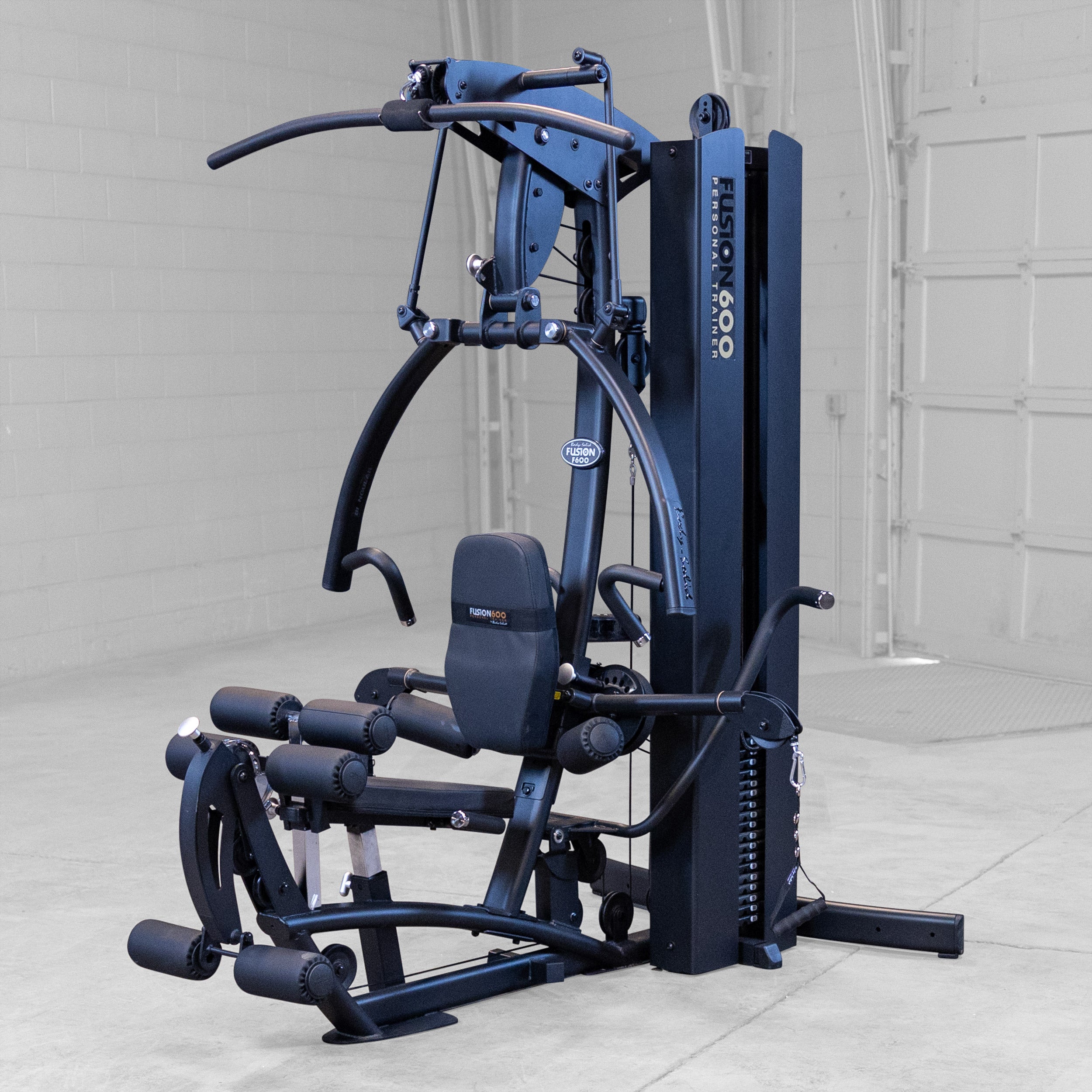 Body-Solid Fusion 600B Personal Trainer in a home gym setting with Bi-Angular Press Arm functional training arms and integrated leg developer