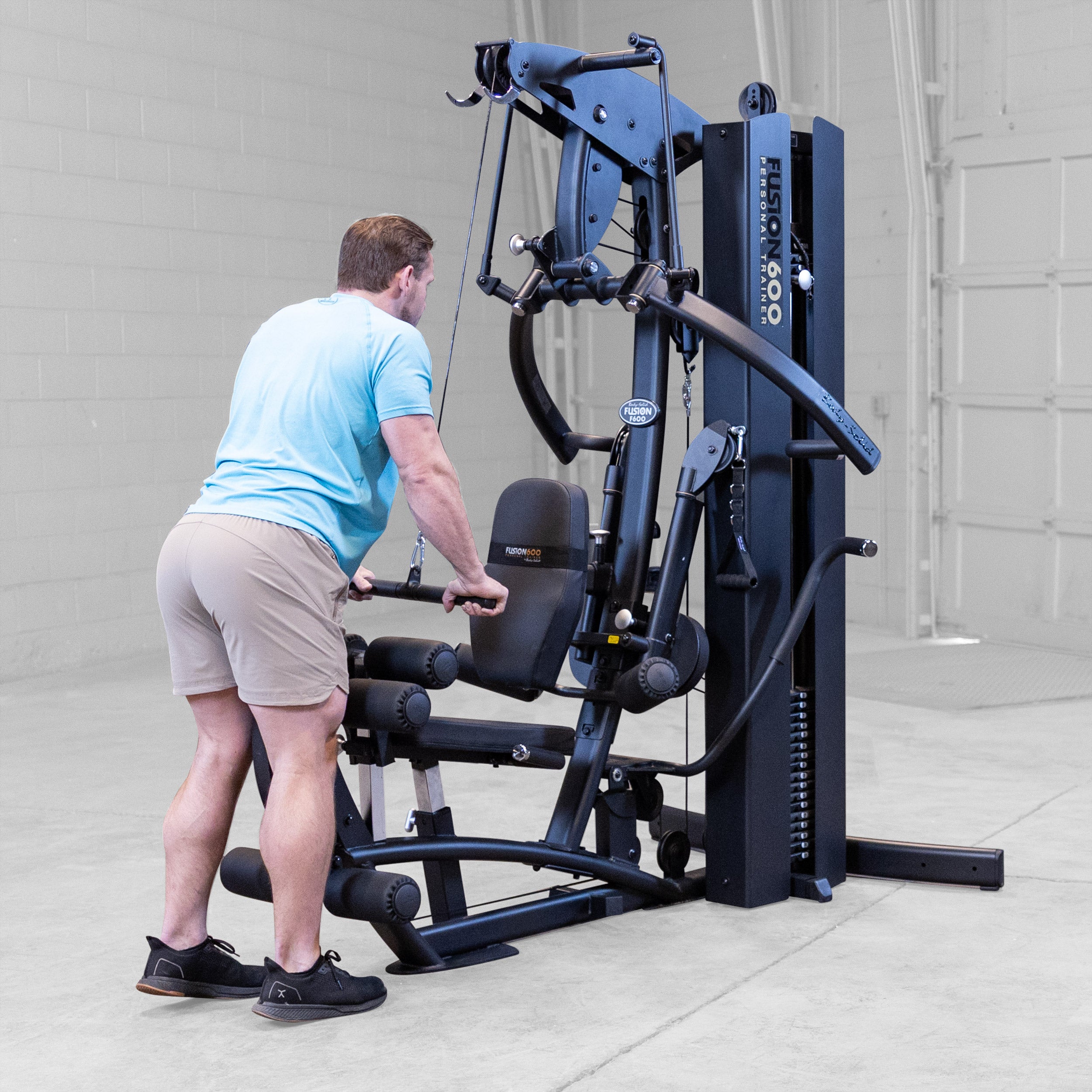 Man performing a tricep pushdown on the Body-Solid Fusion 600B Personal Trainer