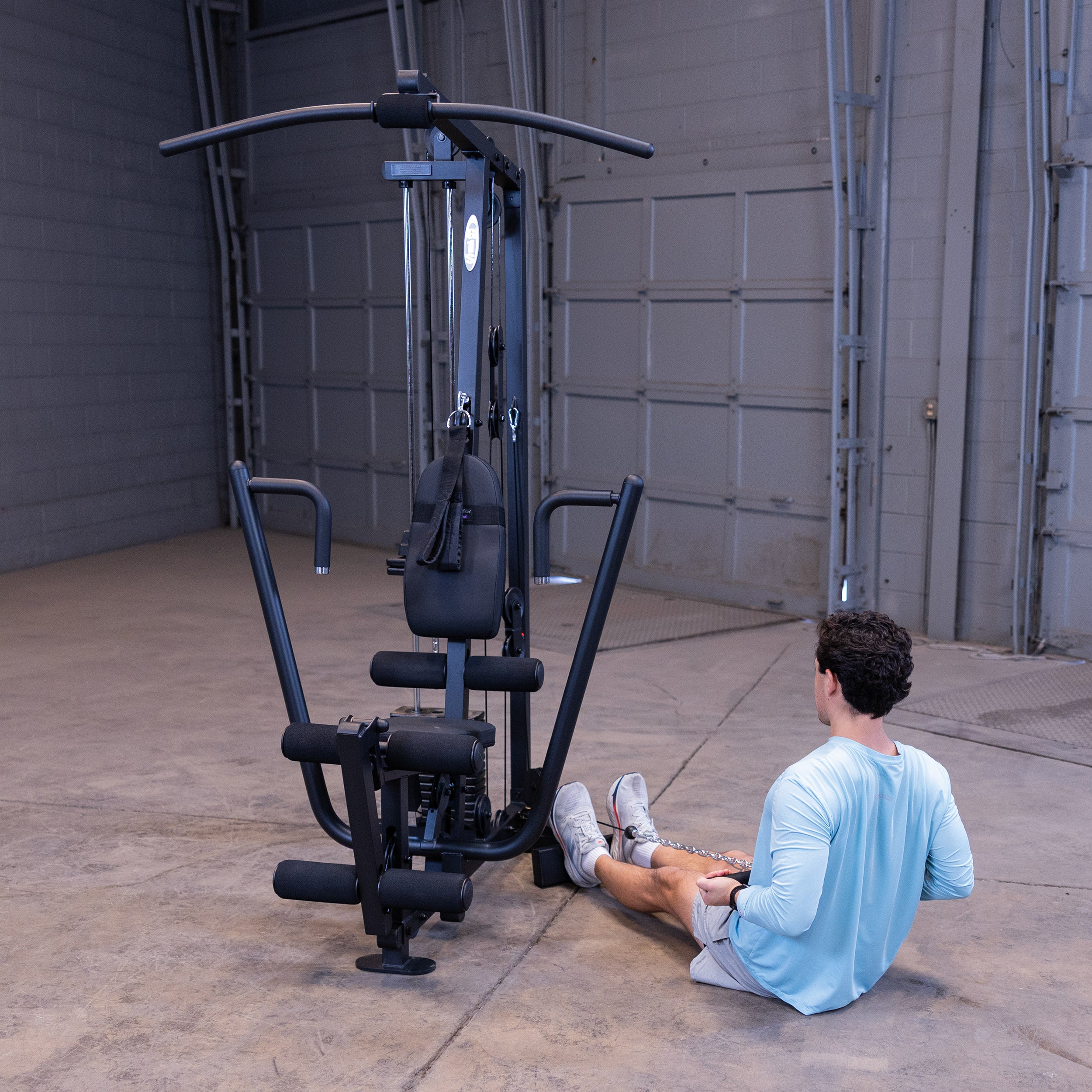 Person performing seated cable rows on the Body-Solid G1B multi station home gym to strengthen the back and biceps
