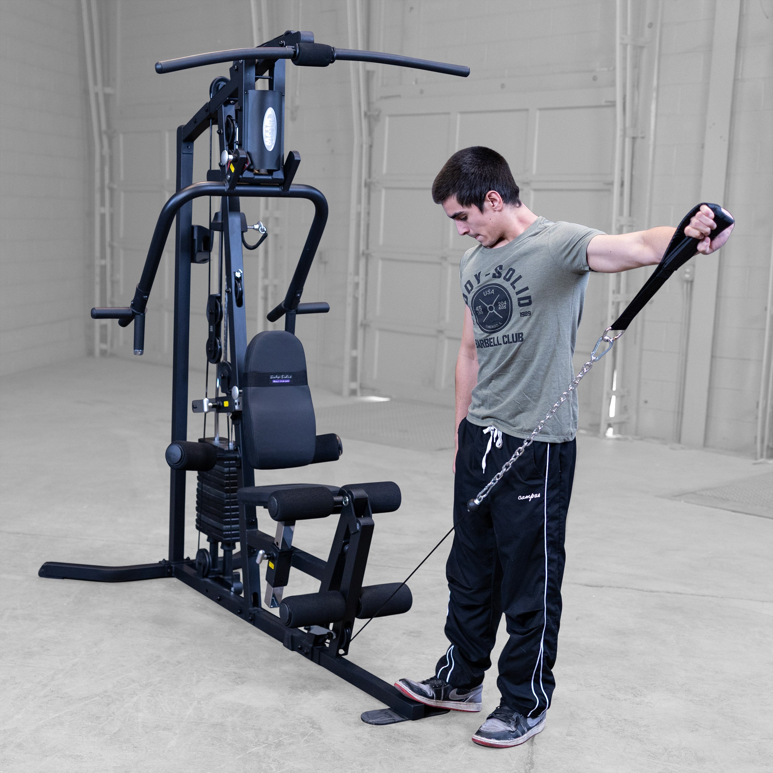 Person performing single arm cable lateral raises on the Body-Solid G3B multi station home gym to strengthen the shoulders