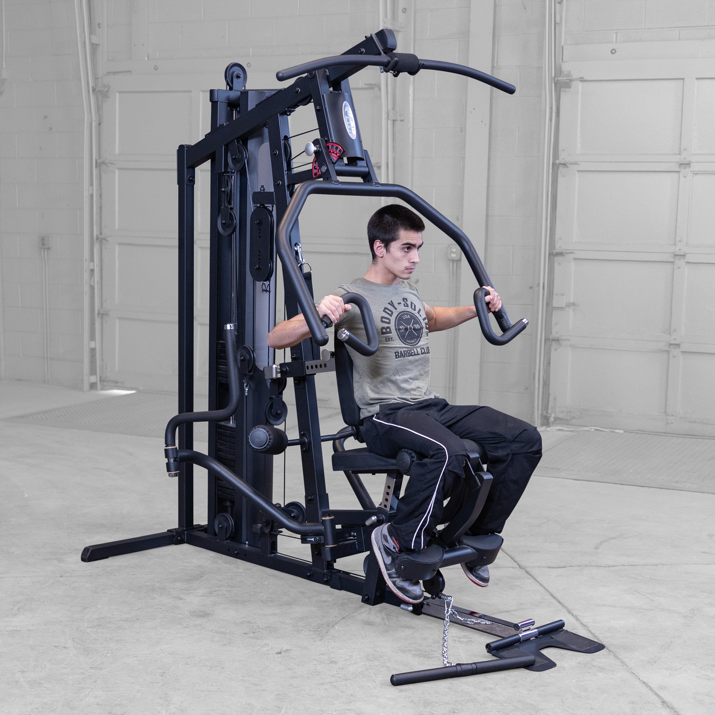 Person performing chest presses on the Body-Solid G5B multi station home gym to strengthen the chest shoulders and triceps