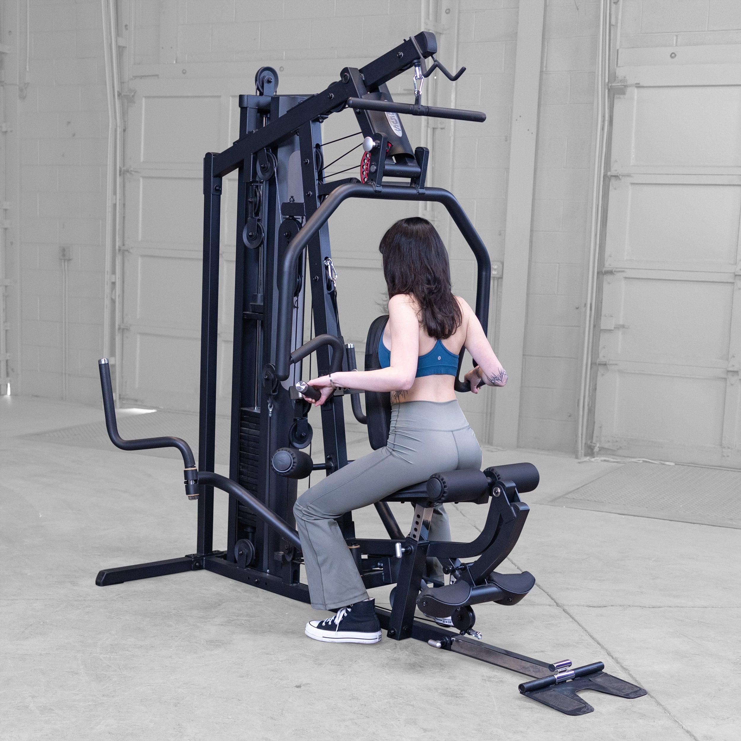 Person performing seated rows on the Body-Solid G5B multi station home gym to strengthen the back shoulders and biceps