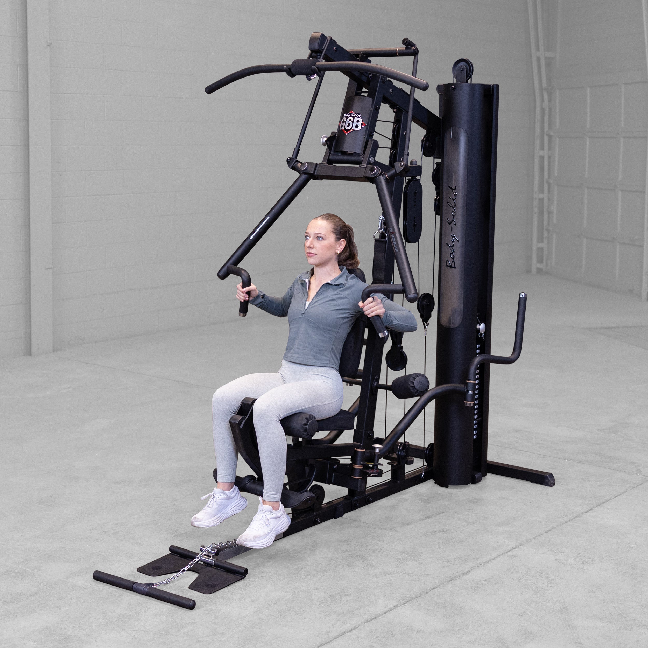 Person performing a chest press exercise on the Body-Solid G6B Bi-Angular home gym