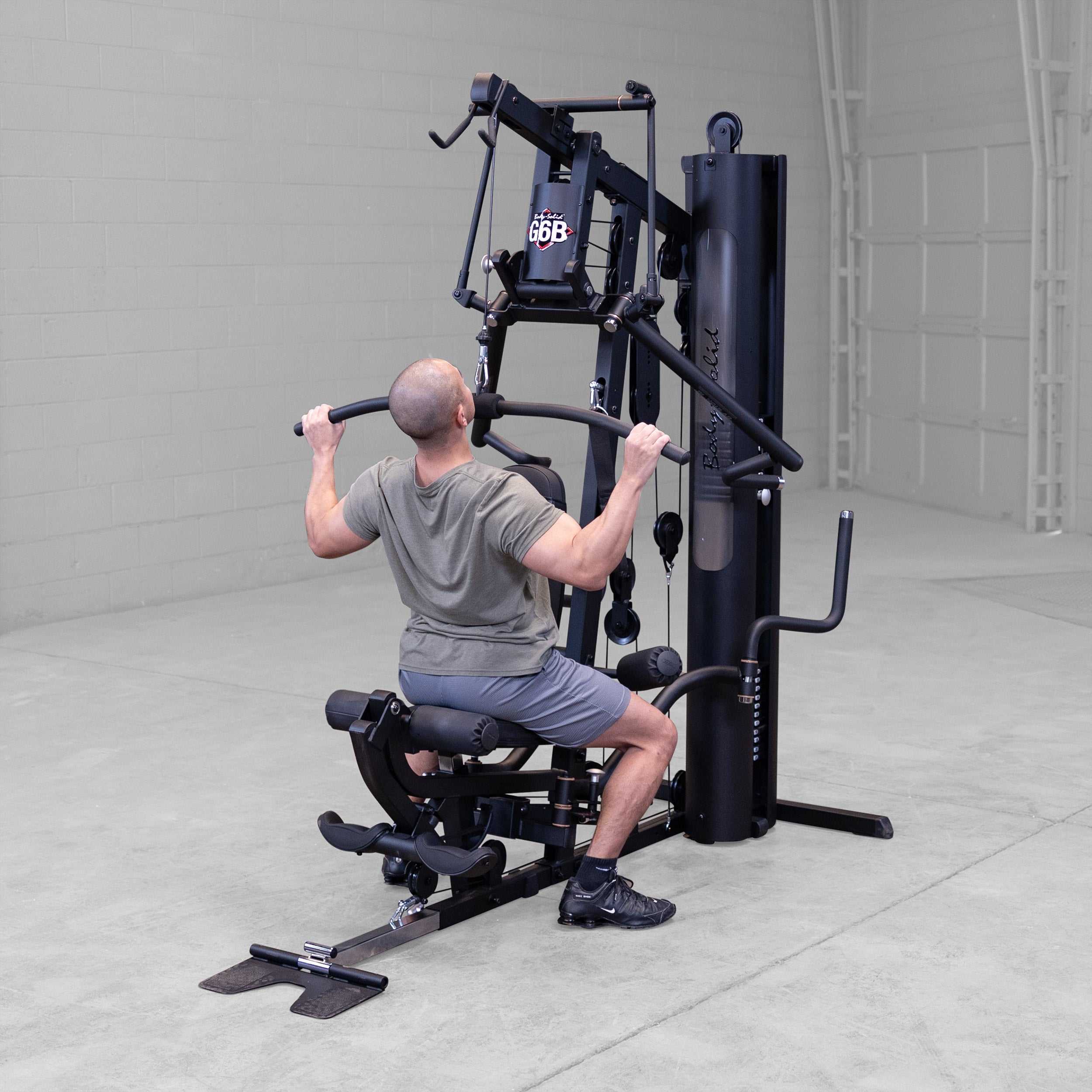 Person performing a lat pulldown exercise on the Body-Solid G6B Bi-Angular home gym