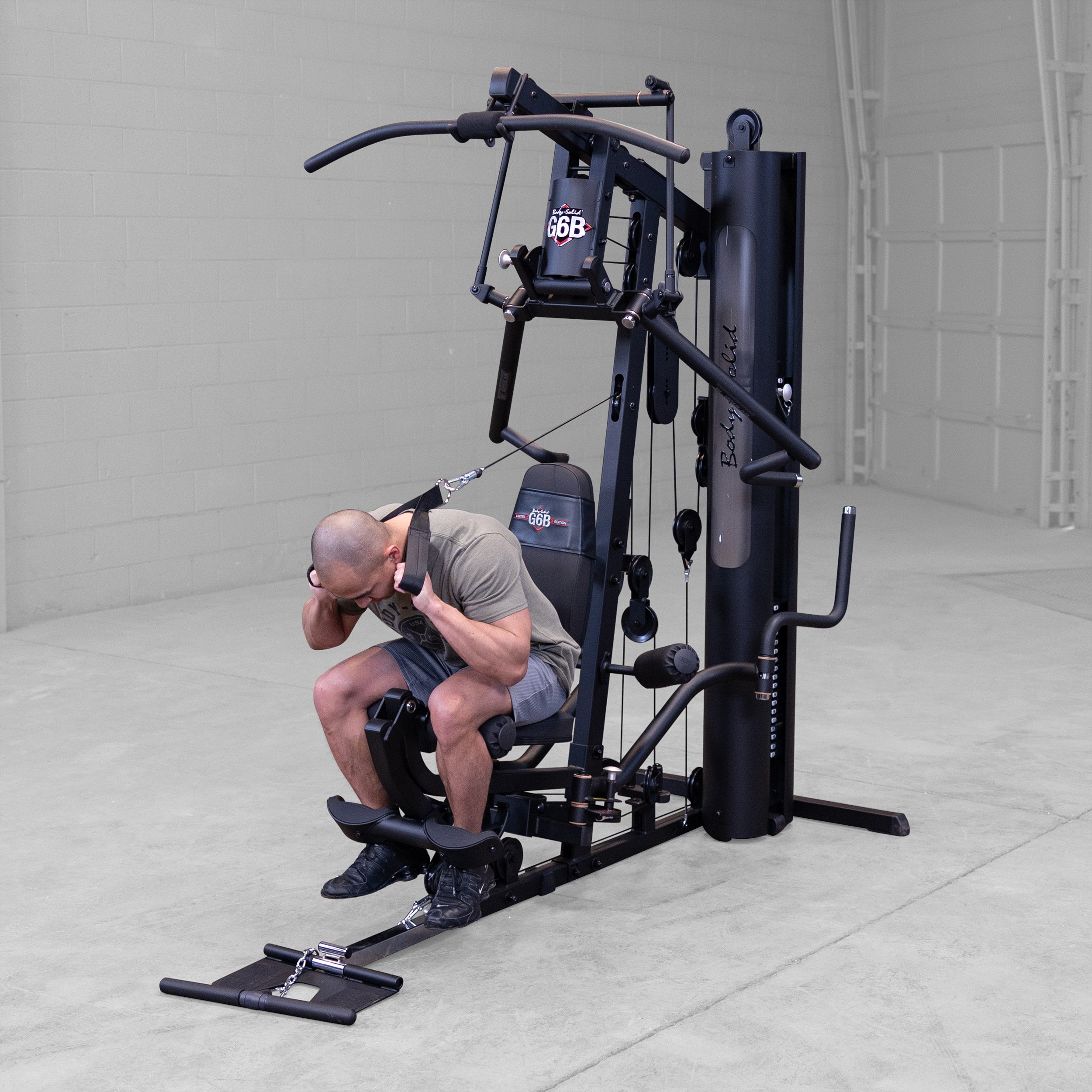 Person performing a seated abdominal crunch exercise on the Body-Solid G6B Bi-Angular home gym