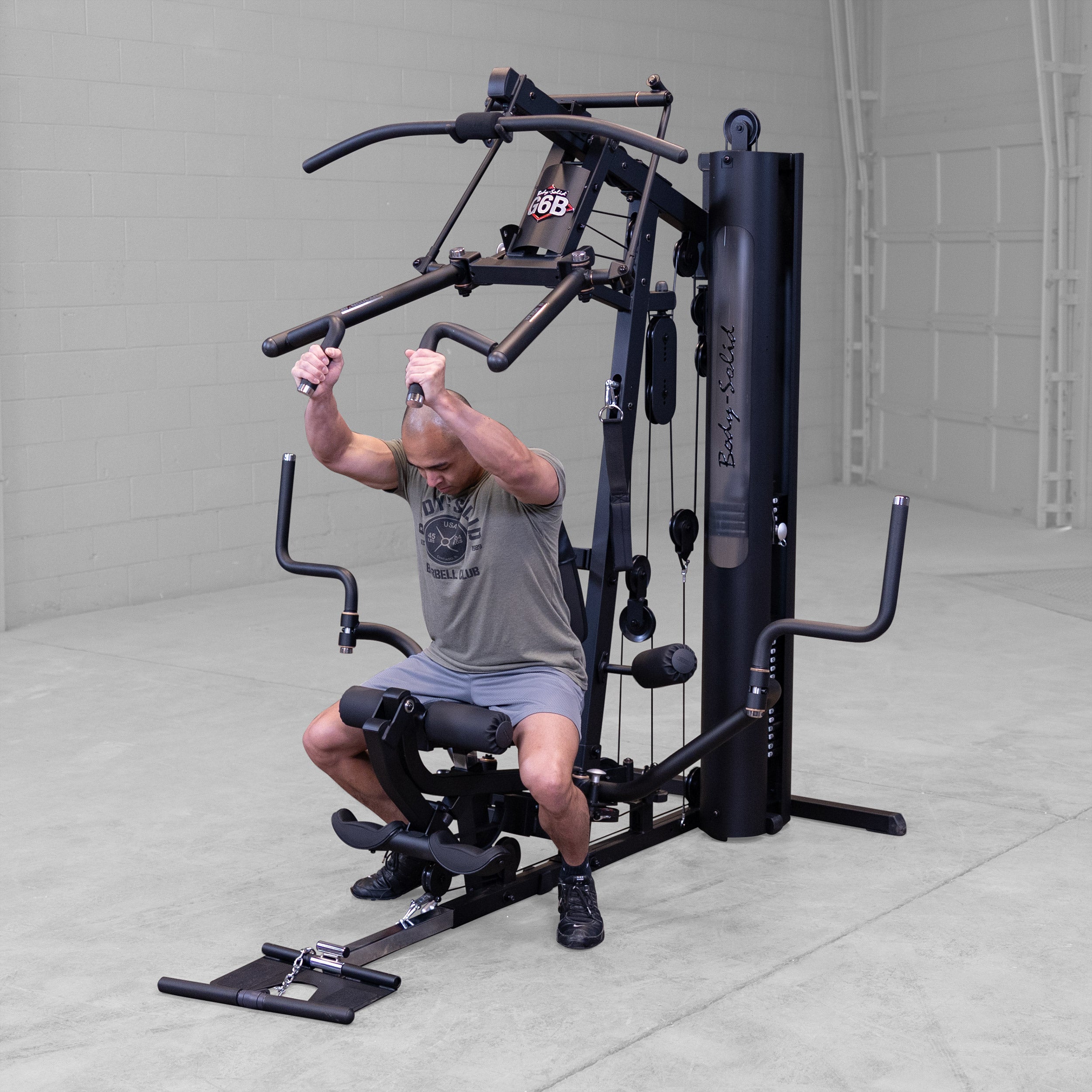 Person performing a shoulder press exercise on the Body-Solid G6B Bi-Angular home gym