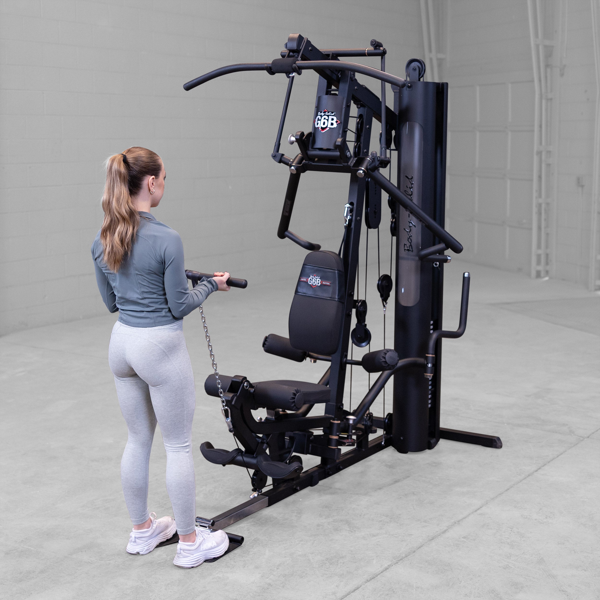 Person performing a standing biceps curl exercise on the Body-Solid G6B Bi-Angular home gym