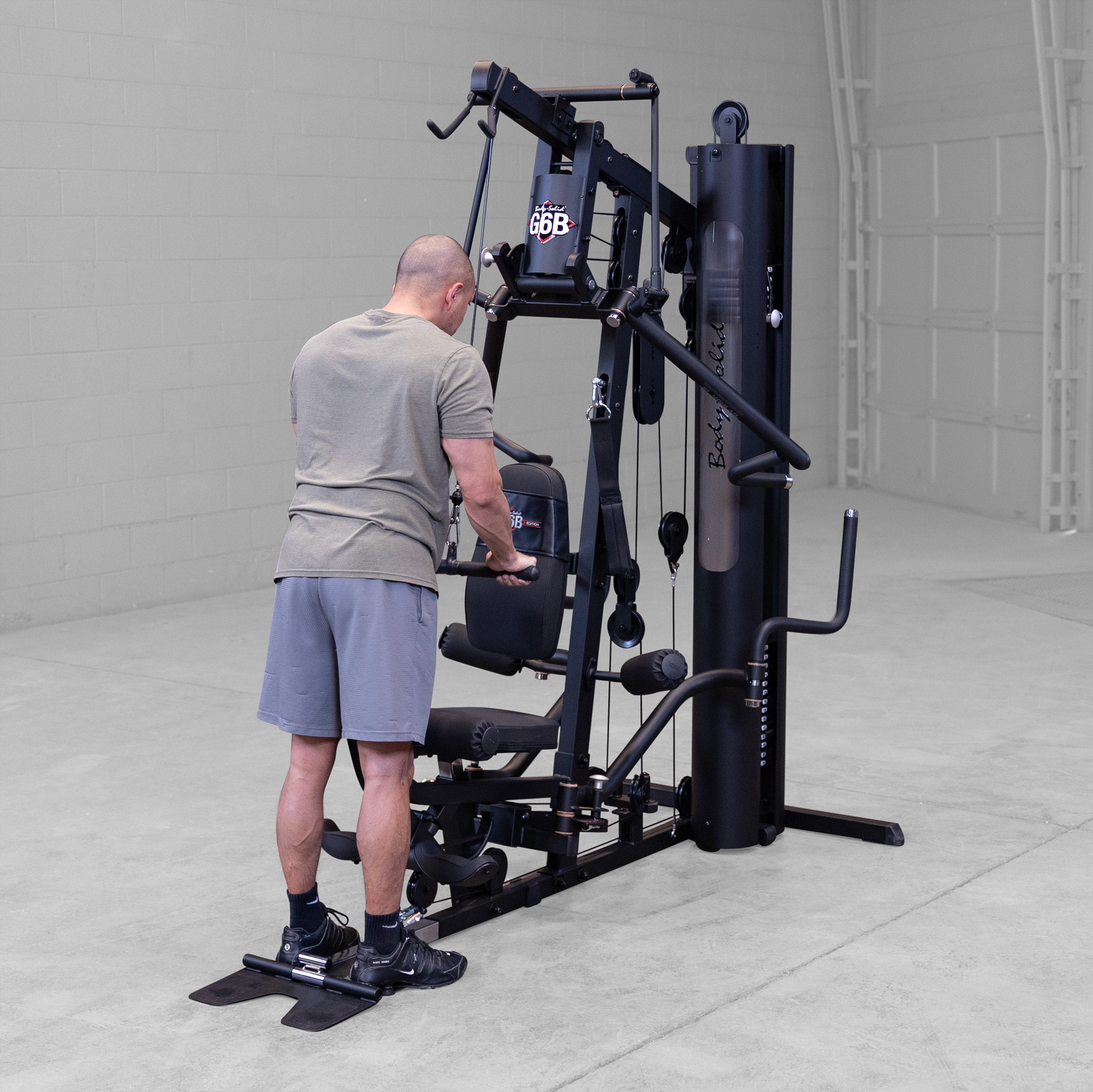 Person performing a triceps pushdown exercise on the Body-Solid G6B Bi-Angular home gym