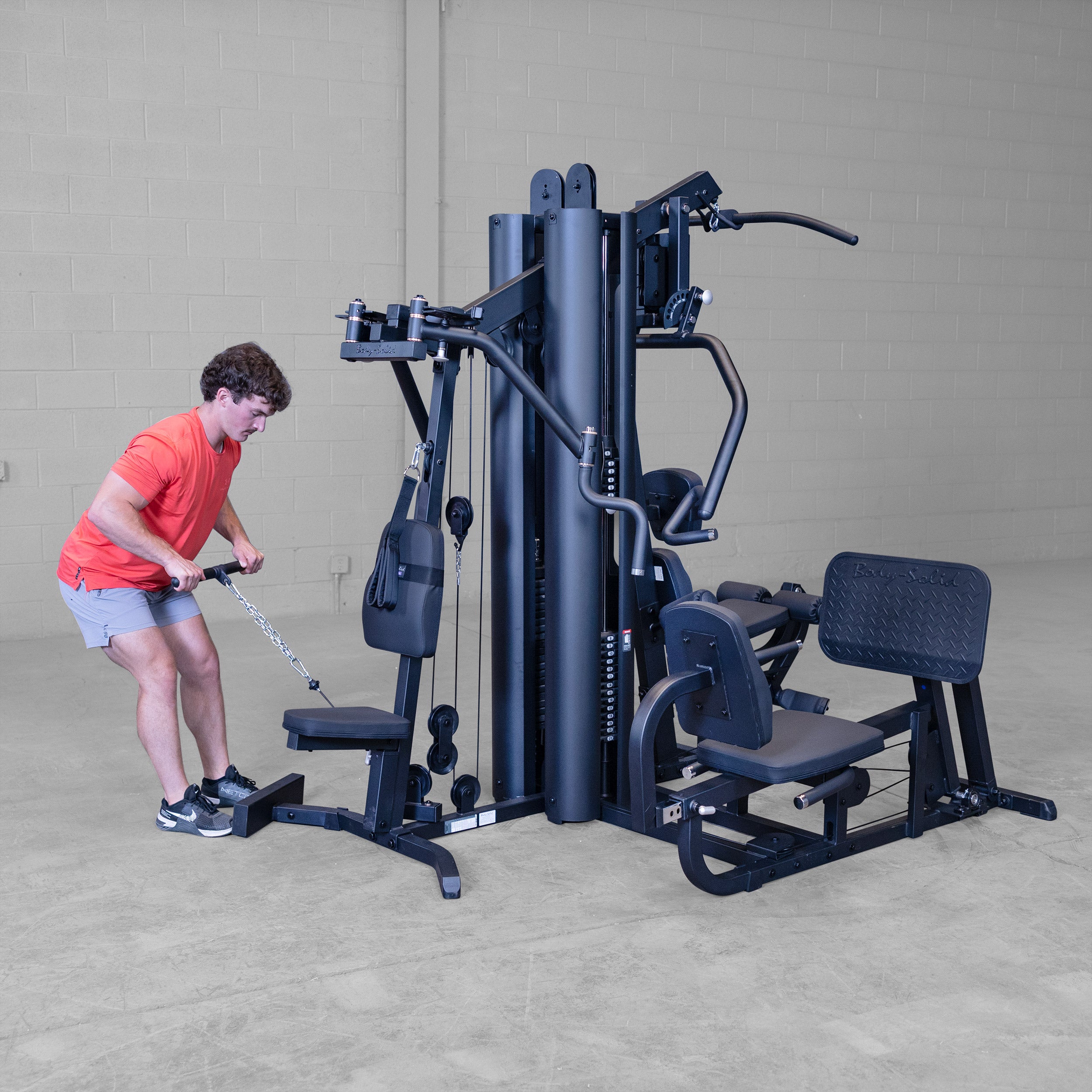 Person performing bent-over low row exercise on the Body-Solid G9B dual stack multi station home gym using the low pulley cable attachment