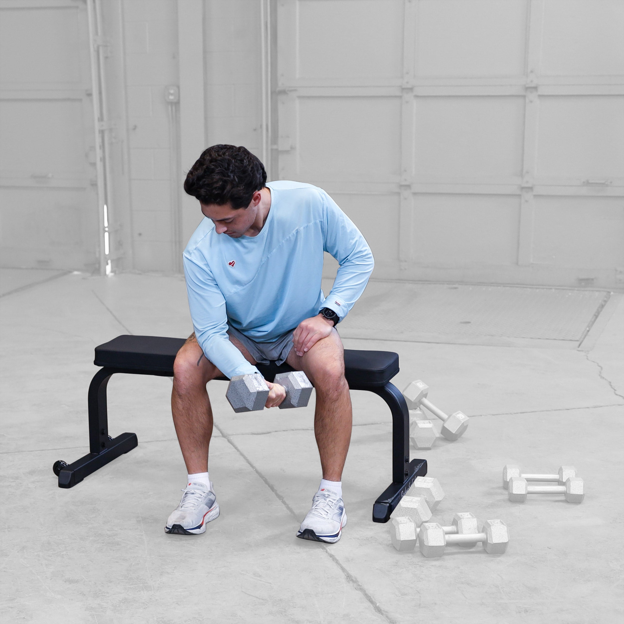 Person performing concentration curls while seated on the Body-Solid GFB350B flat bench